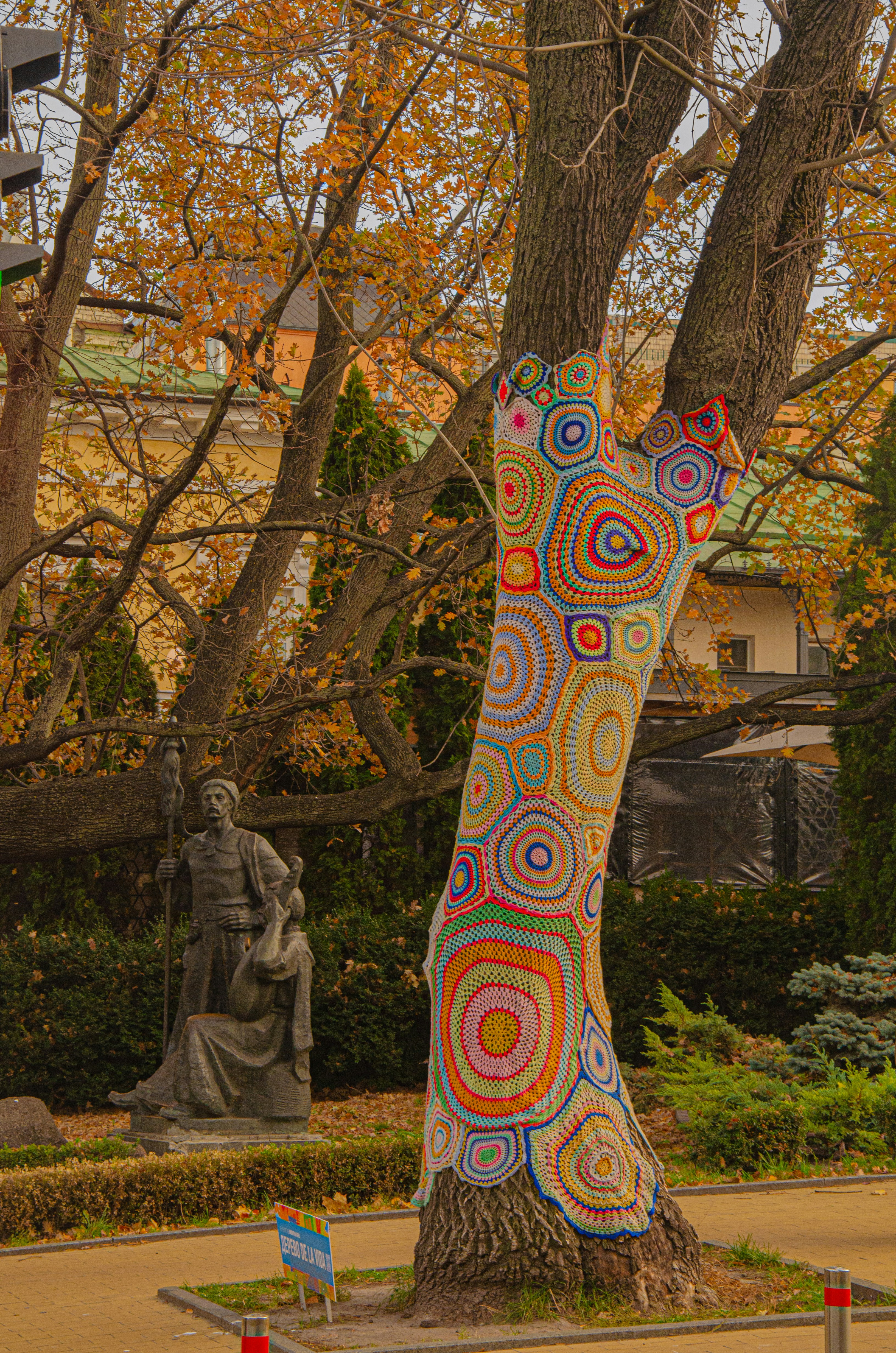 A colorful sculpture of a cat in the middle of a park