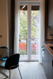 A kitchen with a table, chairs and a sliding glass door