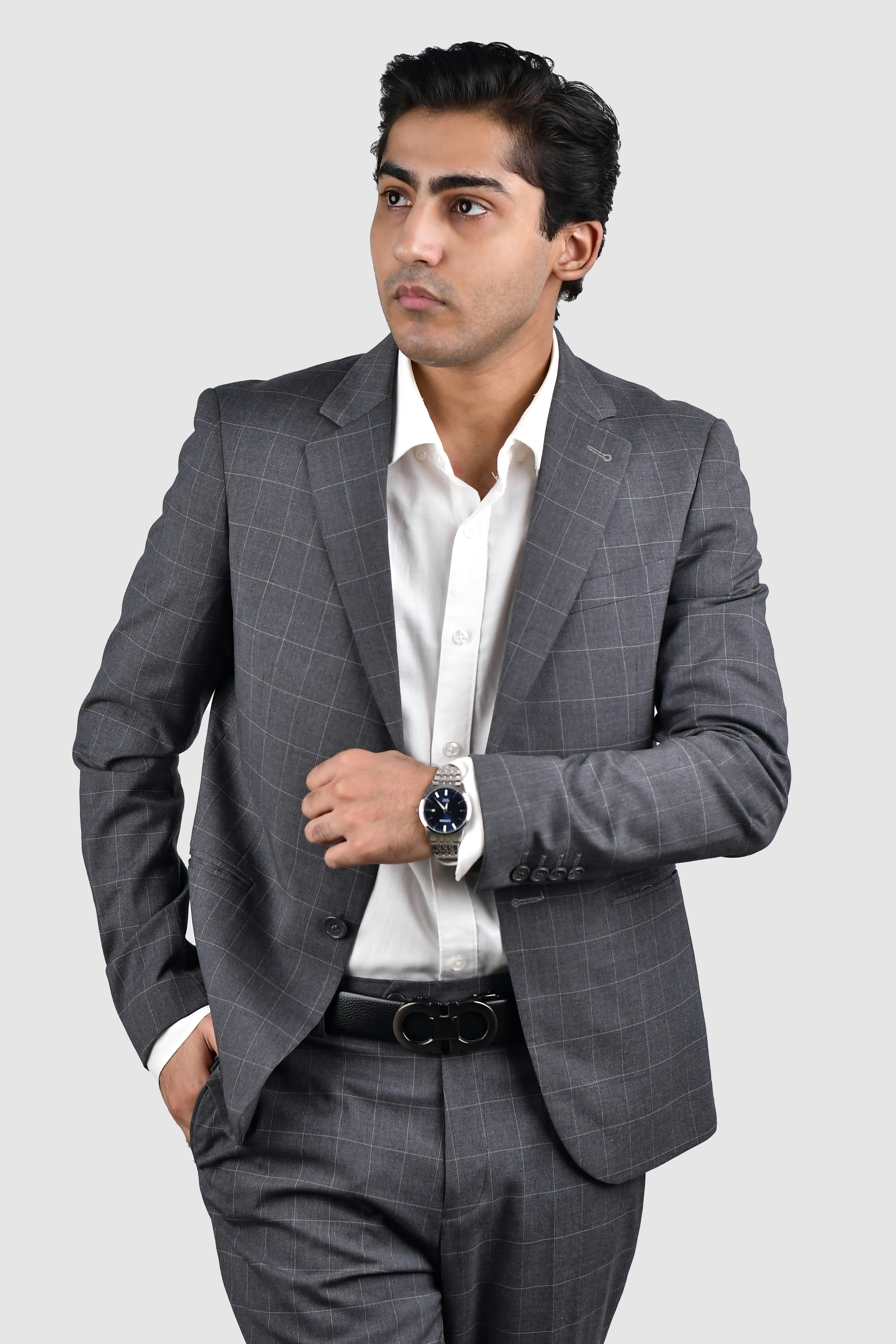 A man in a suit is standing with his hands in his pockets