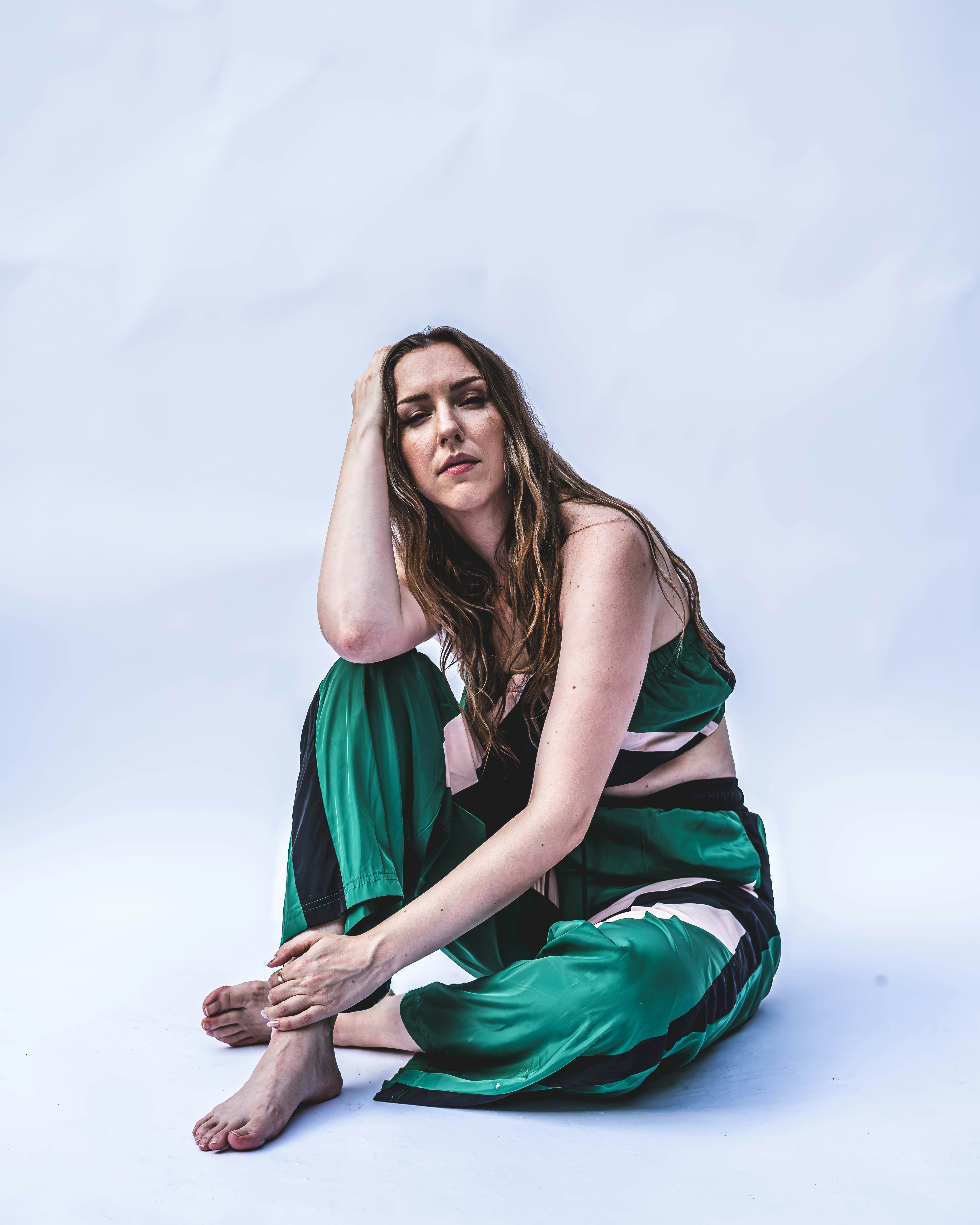 A woman in a green dress sitting on the ground photo – Free Model Image ...