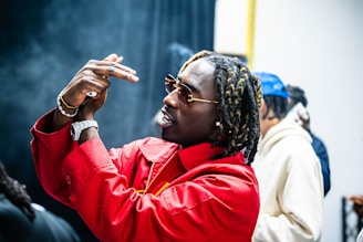 A man in a red jacket pointing at something