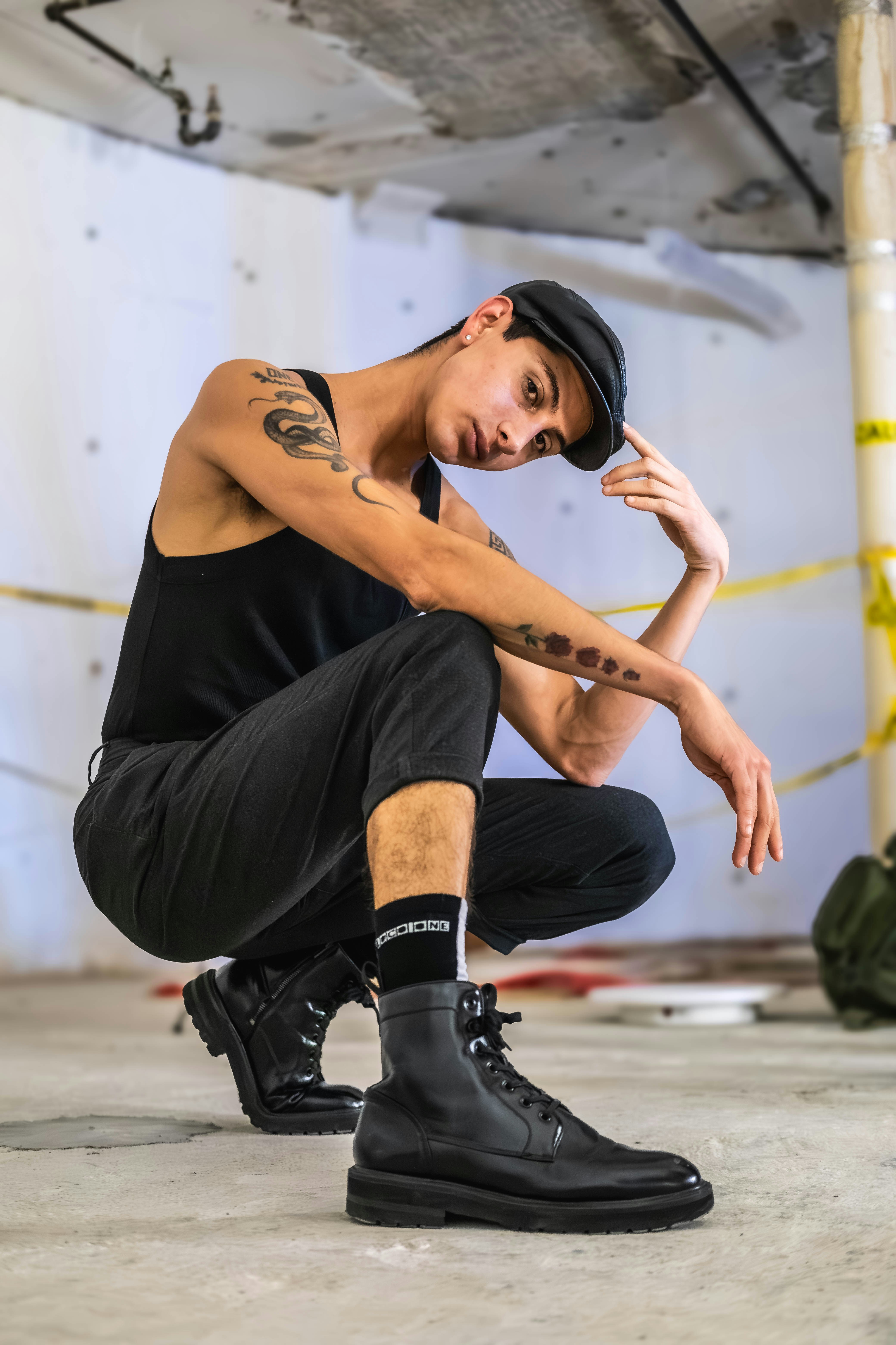 A man sitting on the ground wearing black boots