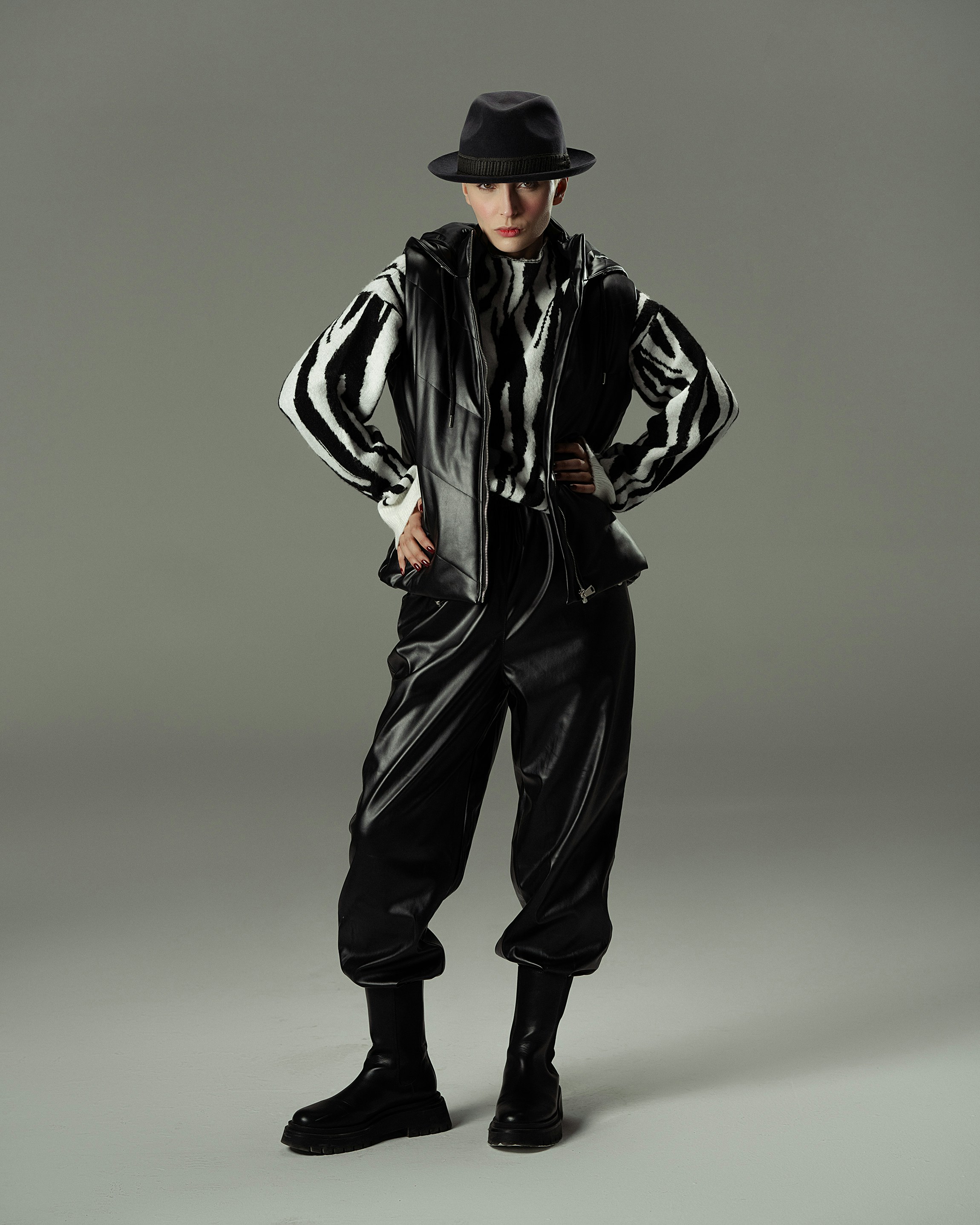 Un homme avec un chapeau noir et une veste noire et blanche