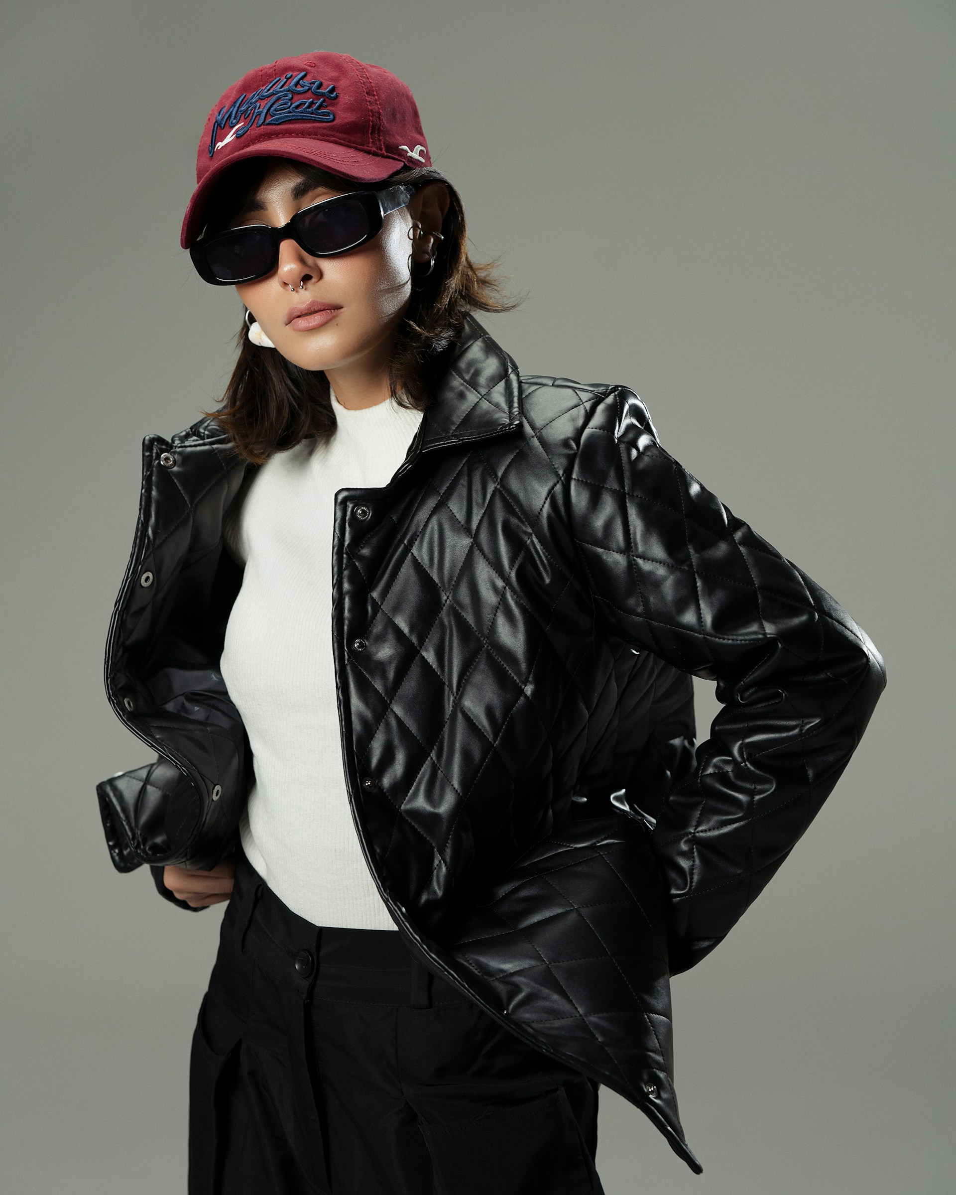 A woman in a black leather jacket and hat