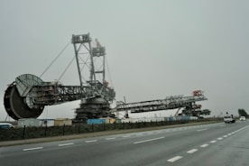 A large crane sitting on the side of a road
