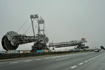 A large crane sitting on the side of a road