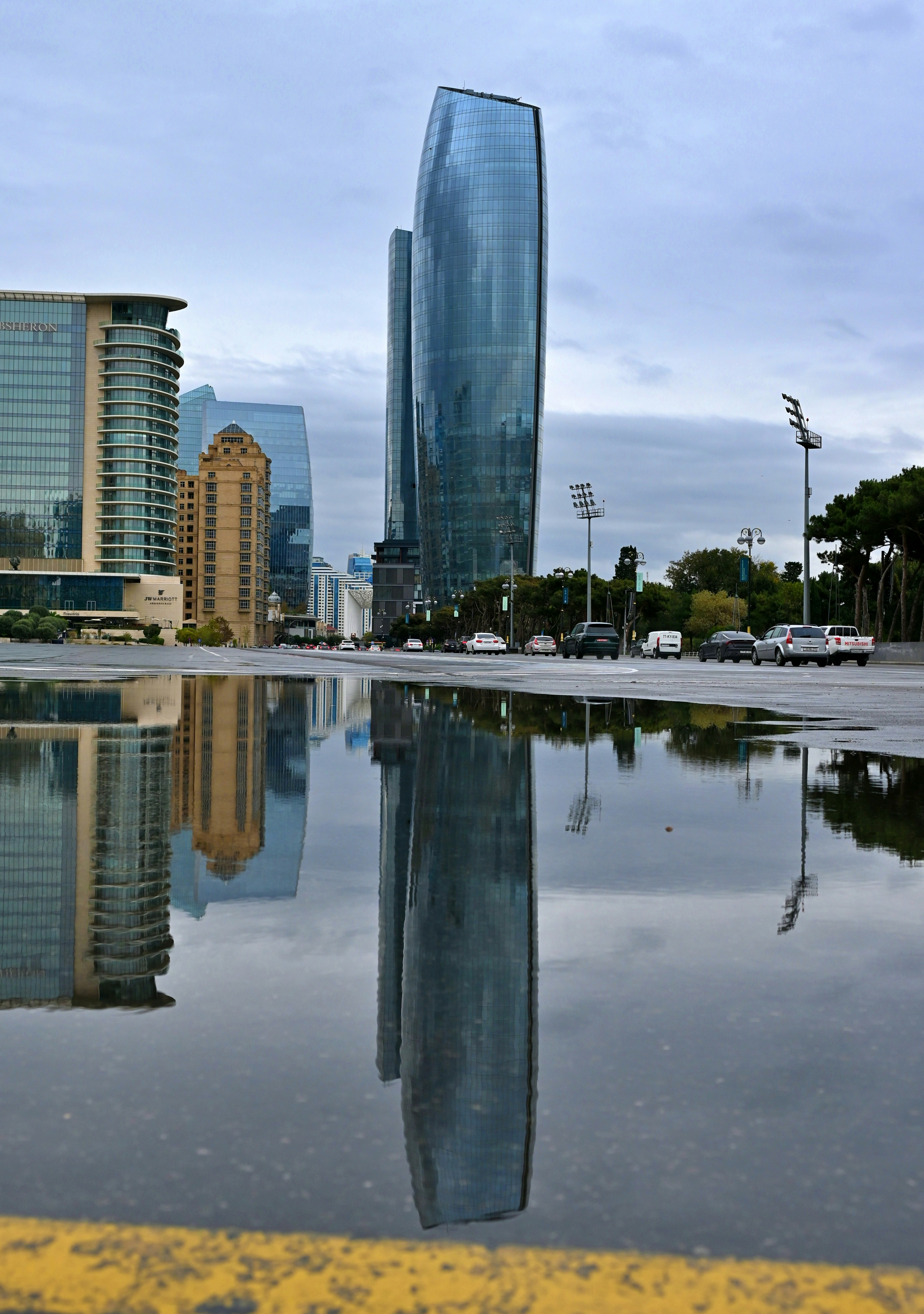 City skyline reflected perfectly in a rain puddle on street, pedestrians walking past unaware