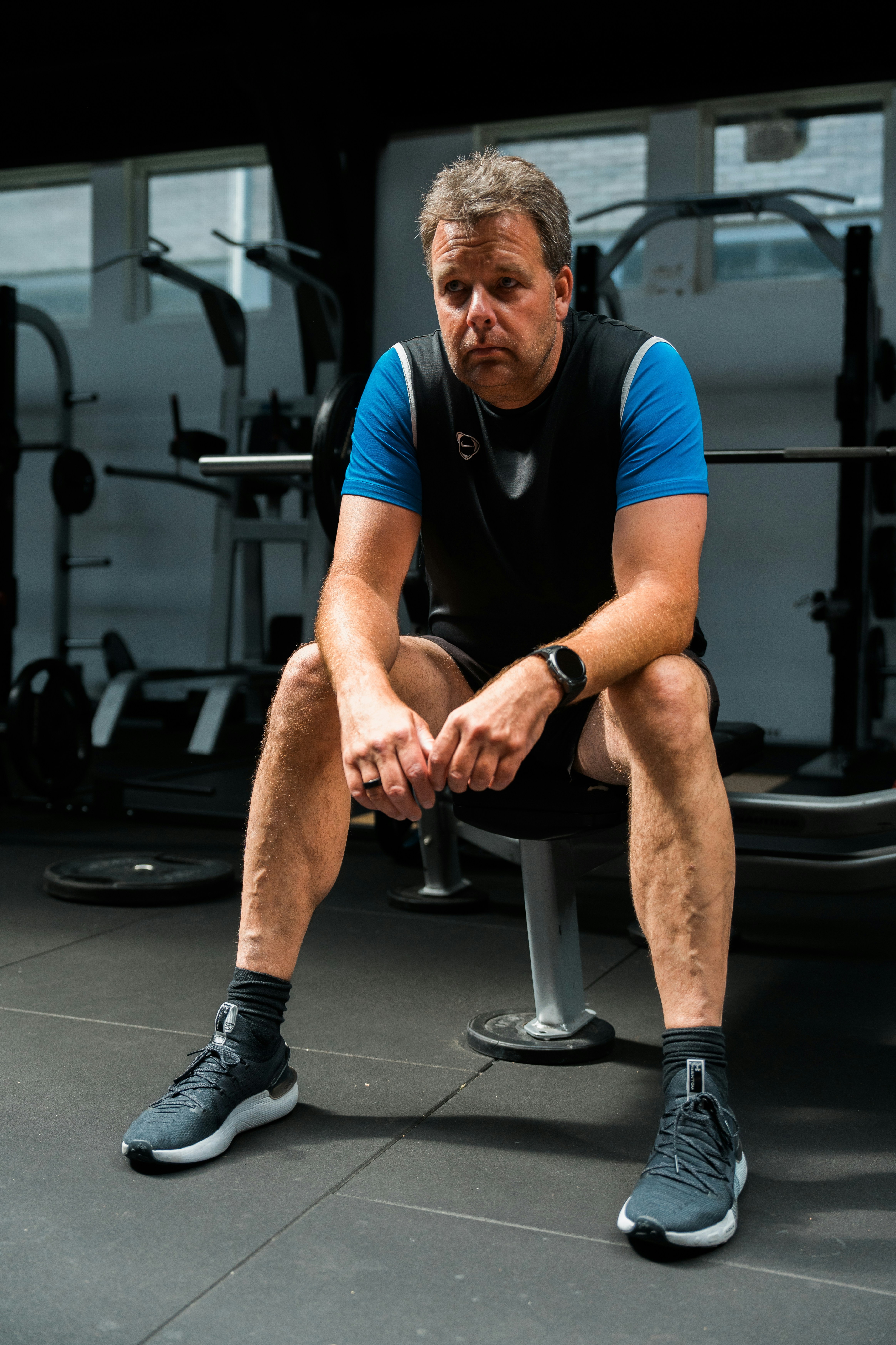 A man sitting on a bench in a gym