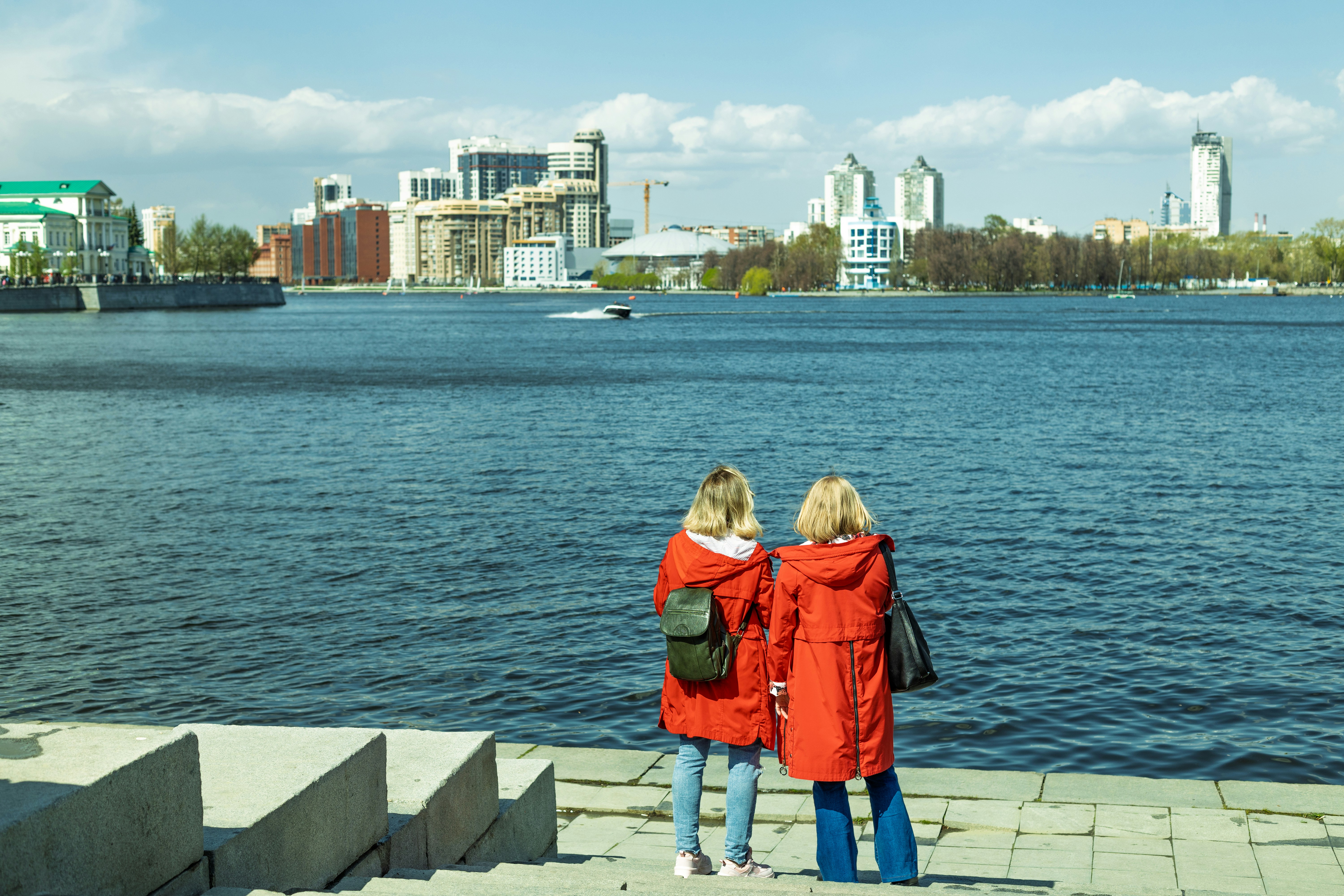 Two women standing on the edge of a pier looking at the water