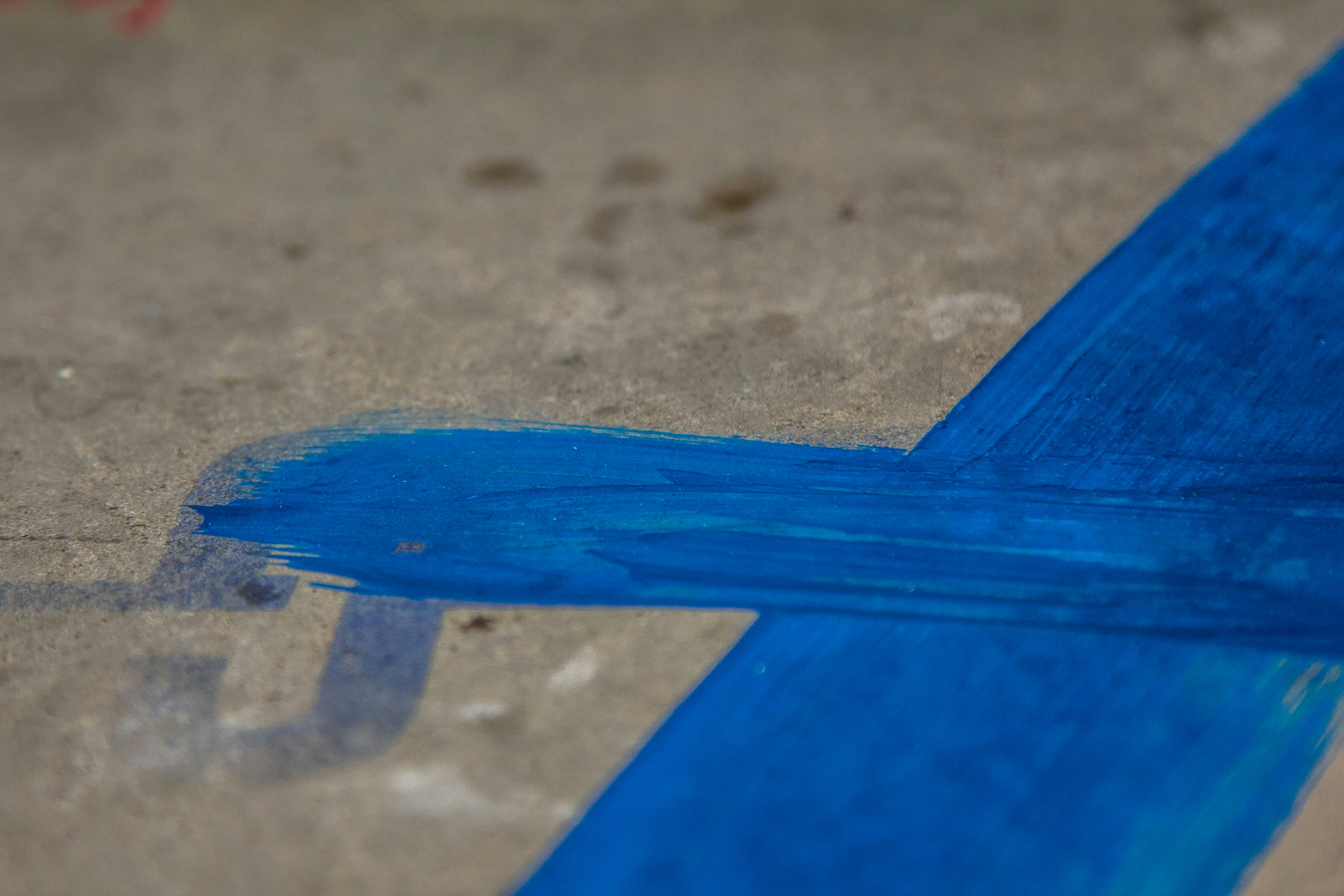 A close up of a blue arrow painted on the ground