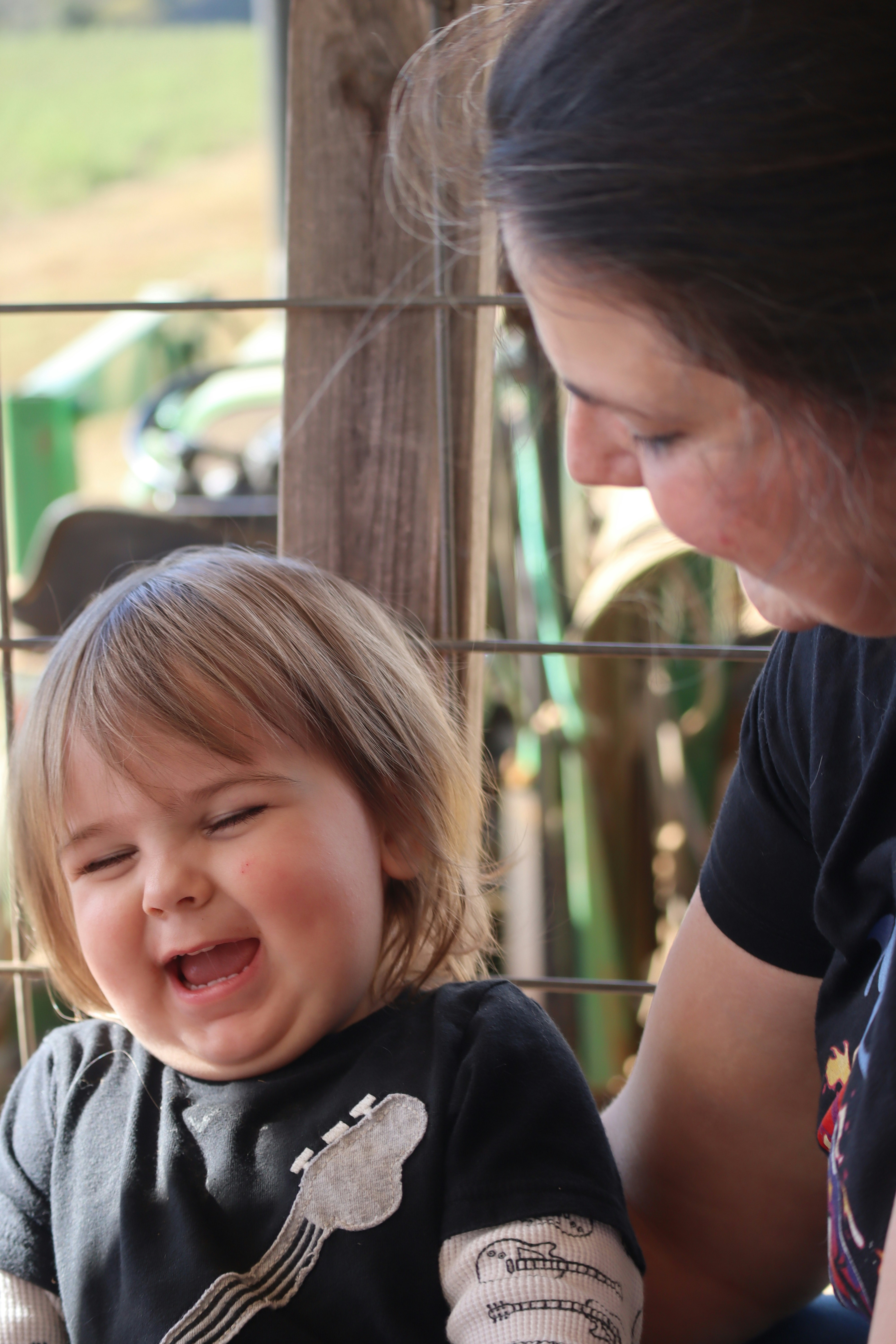 A little girl crying while sitting next to a woman