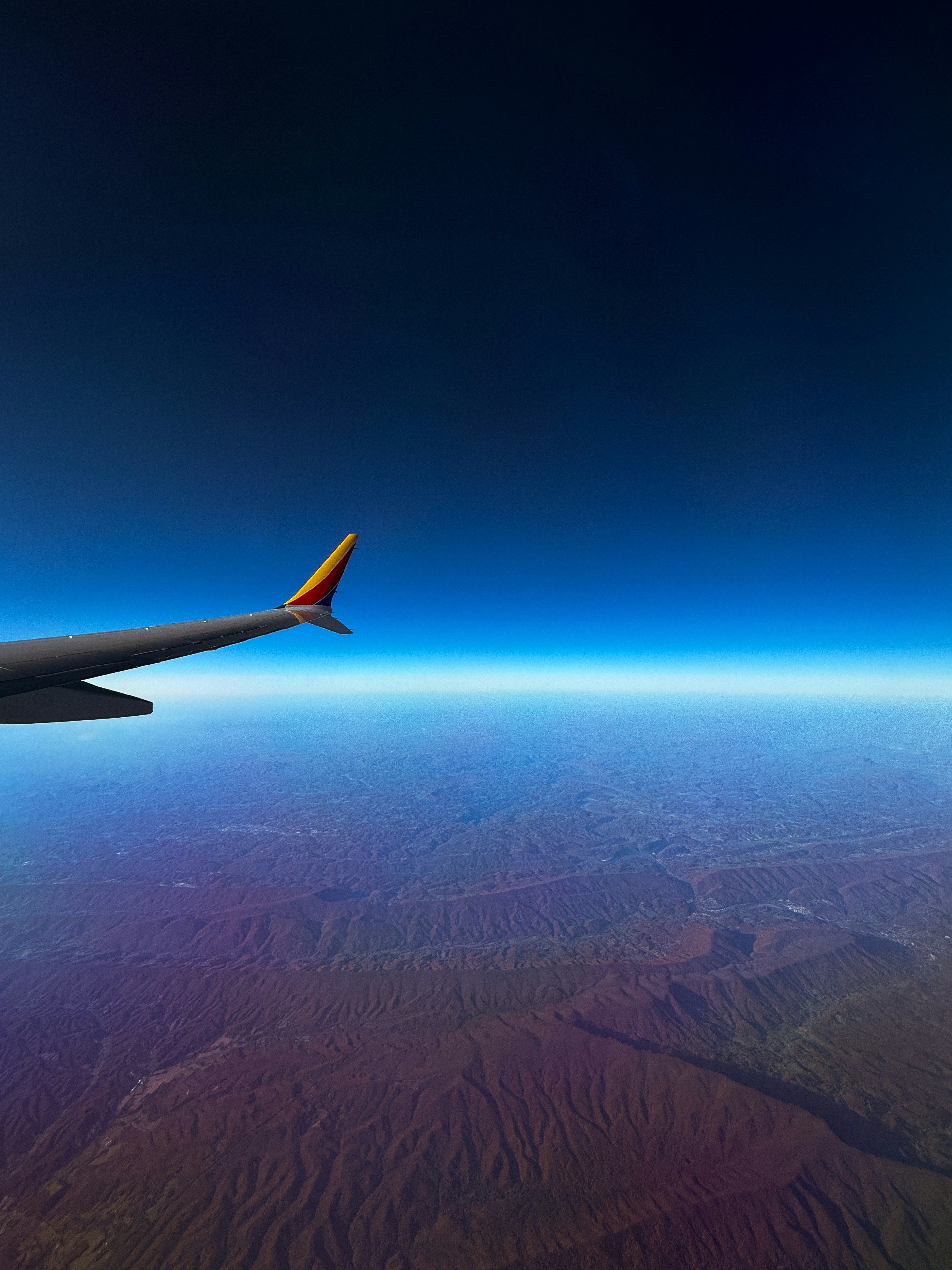 A view of the wing of an airplane in the sky