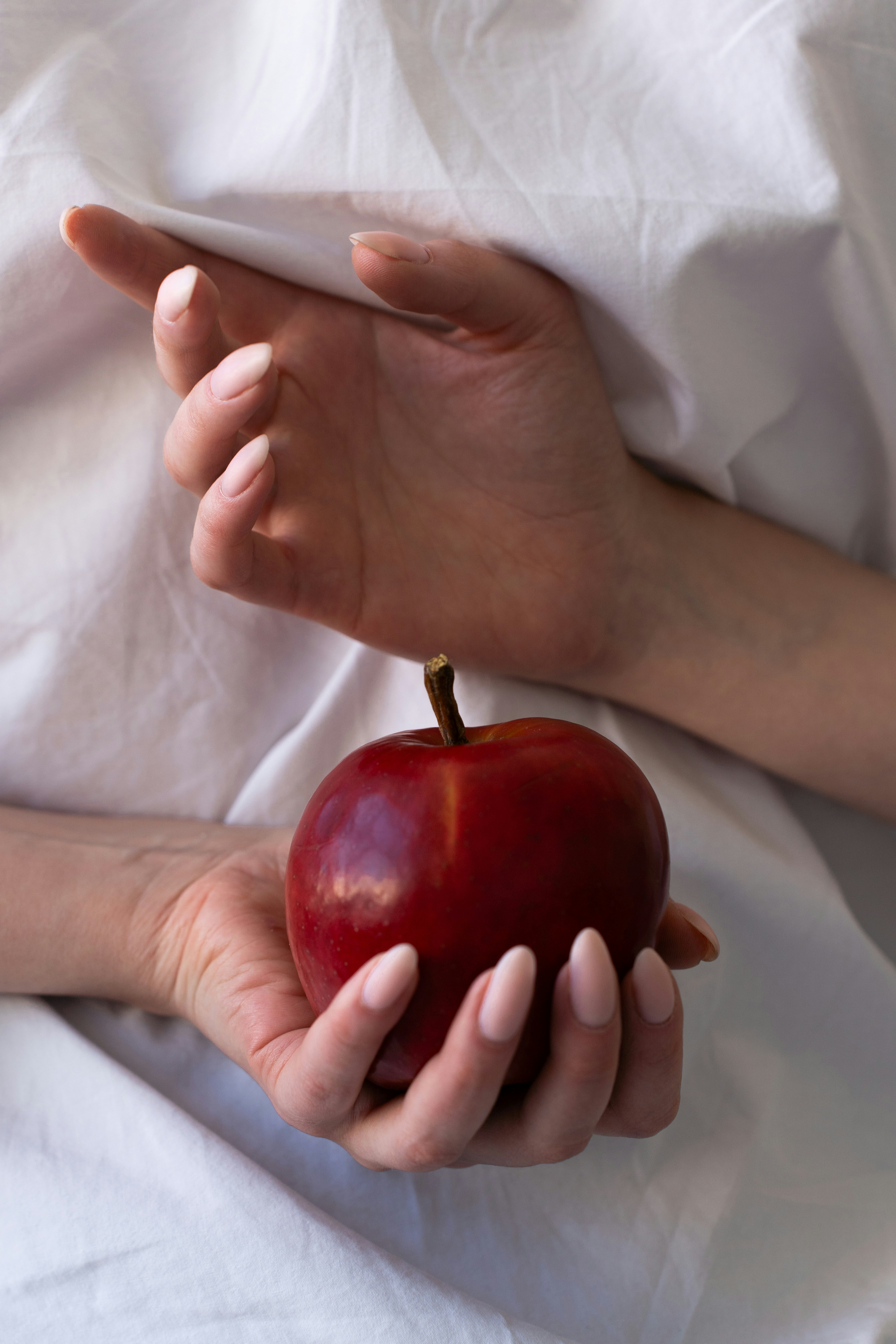 A person holding an apple in their hands