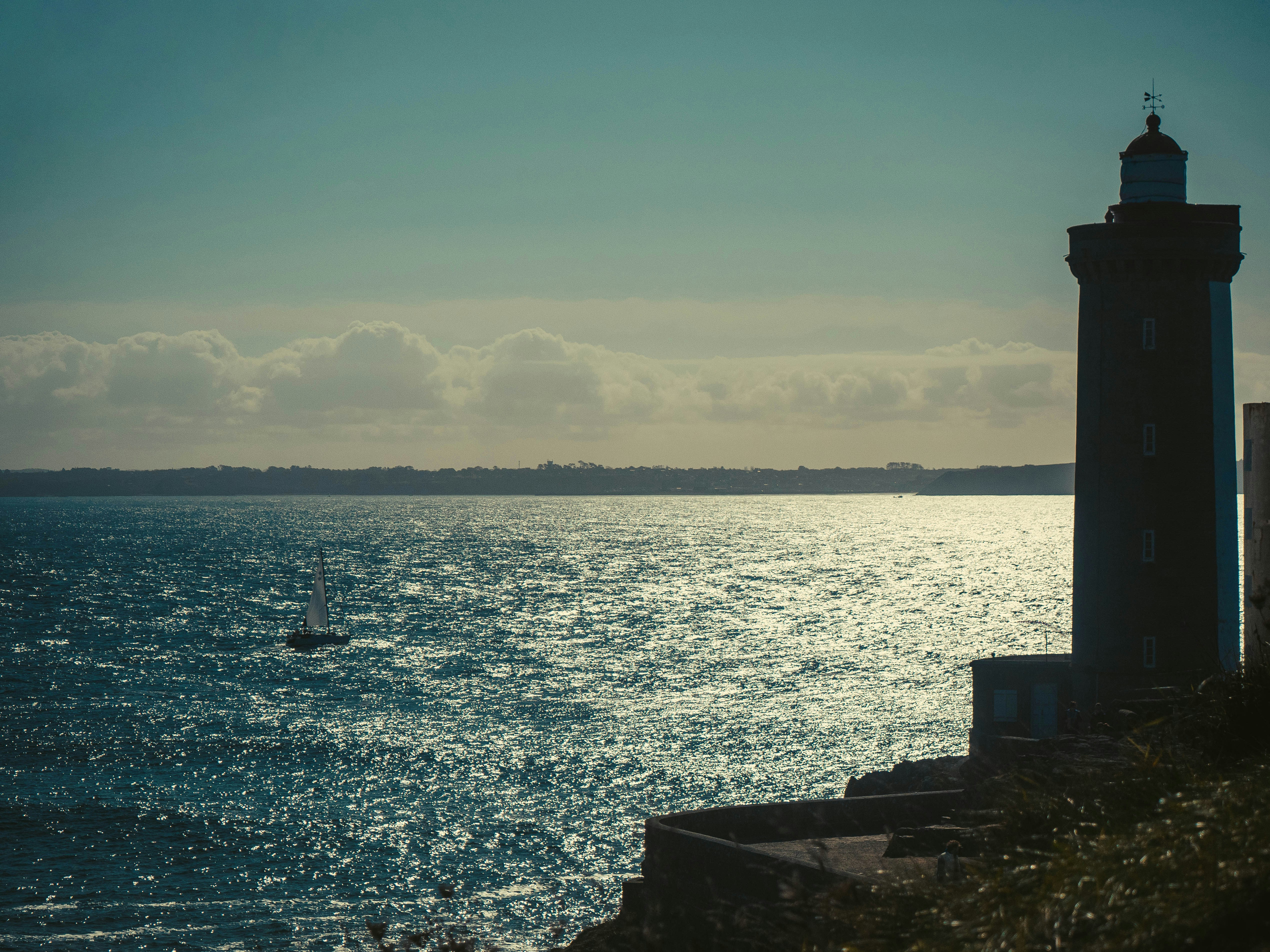 A lighthouse sitting on top of a cliff next to the ocean