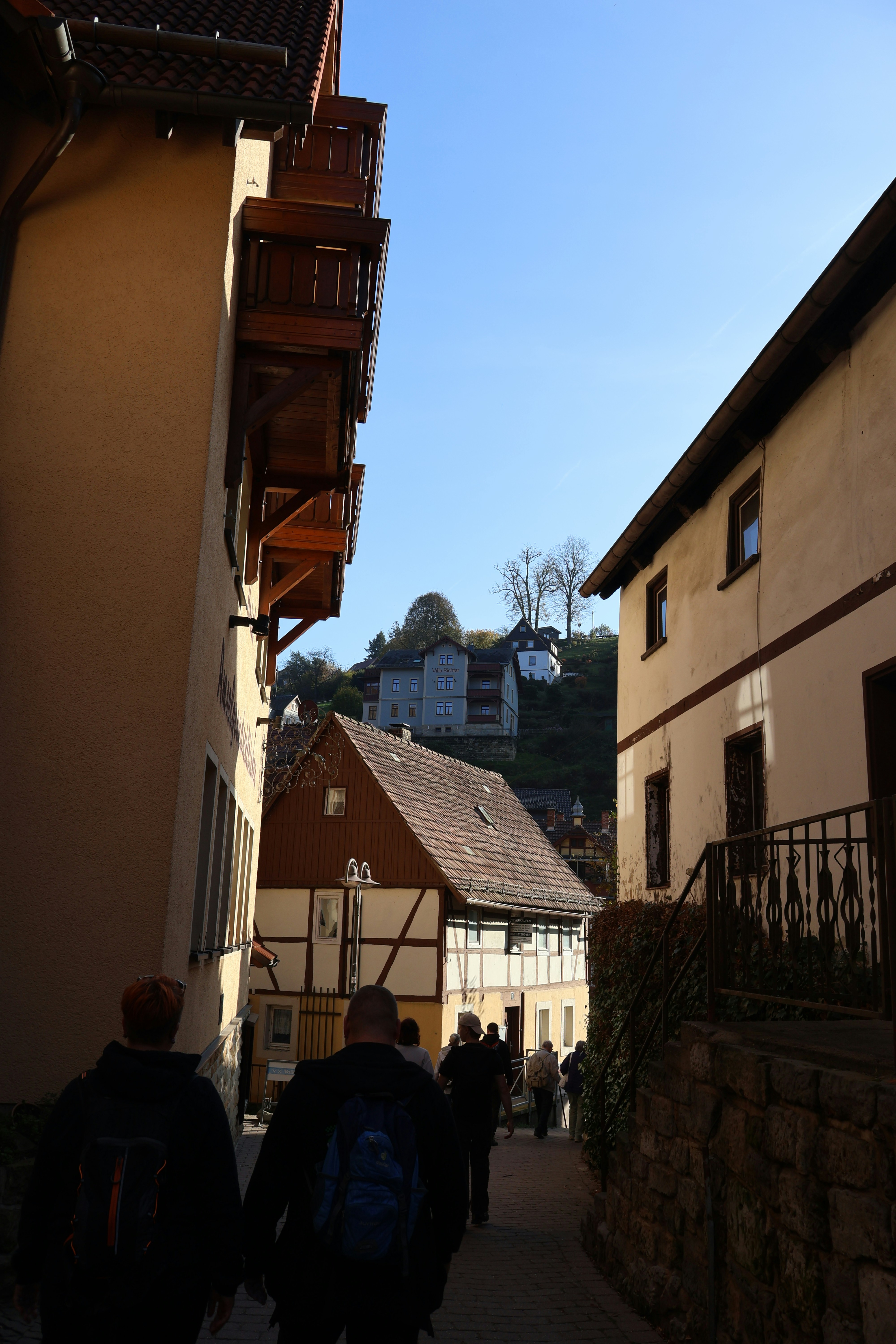 A group of people walking down a street next to buildings