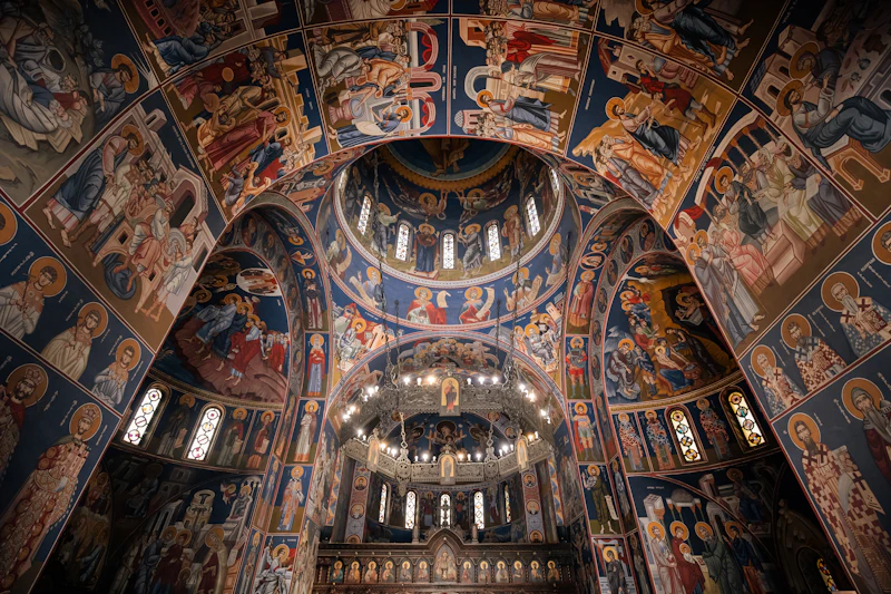 Walls covered in Byzantine frescoes and icons inside a Greek Orthodox church