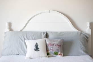 A bed with a white headboard and two pillows