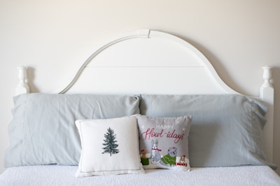 A bed with a white headboard and two pillows