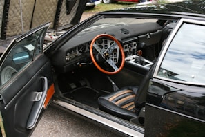 A black car with a red steering wheel