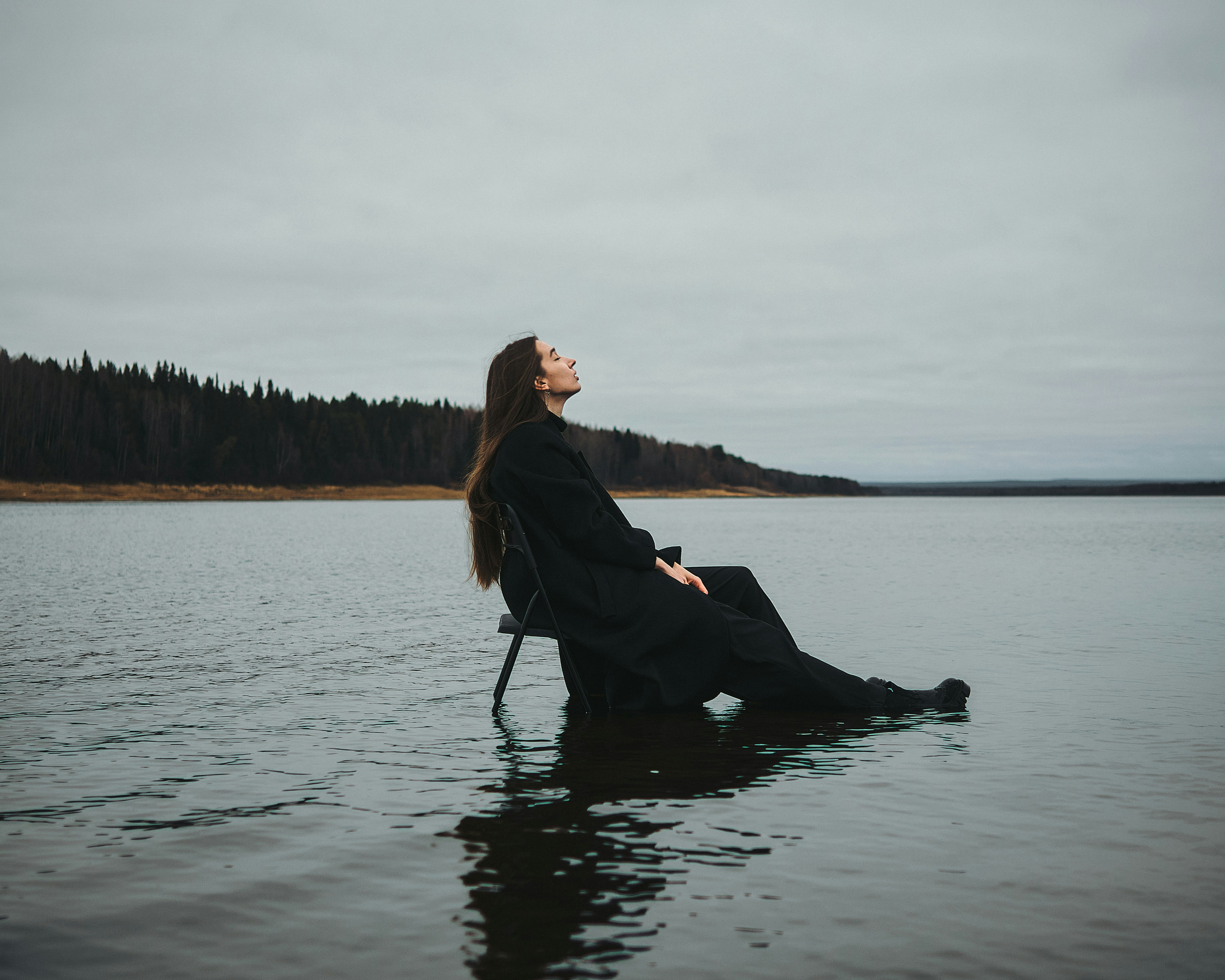A woman sitting on a chair in the water