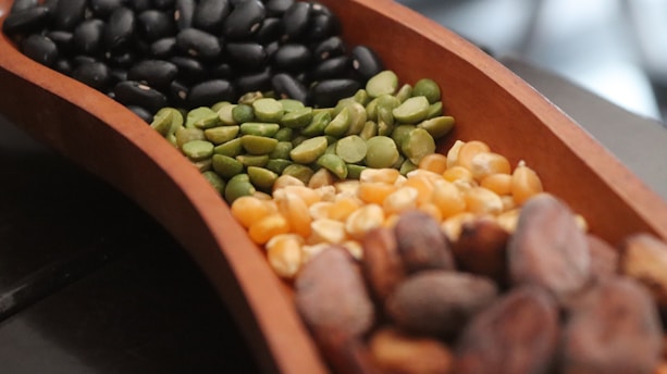 A wooden bowl filled with different types of nuts