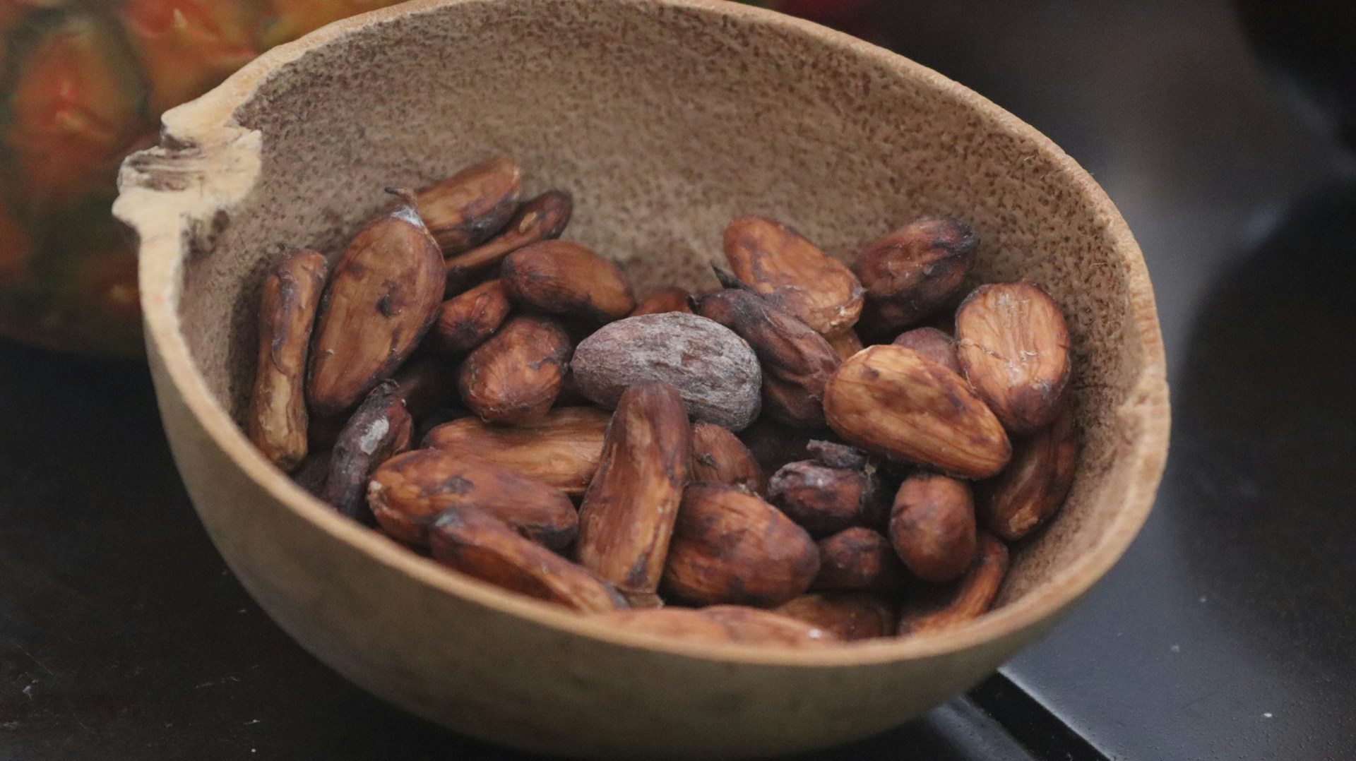 A wooden bowl filled with nuts on top of a table