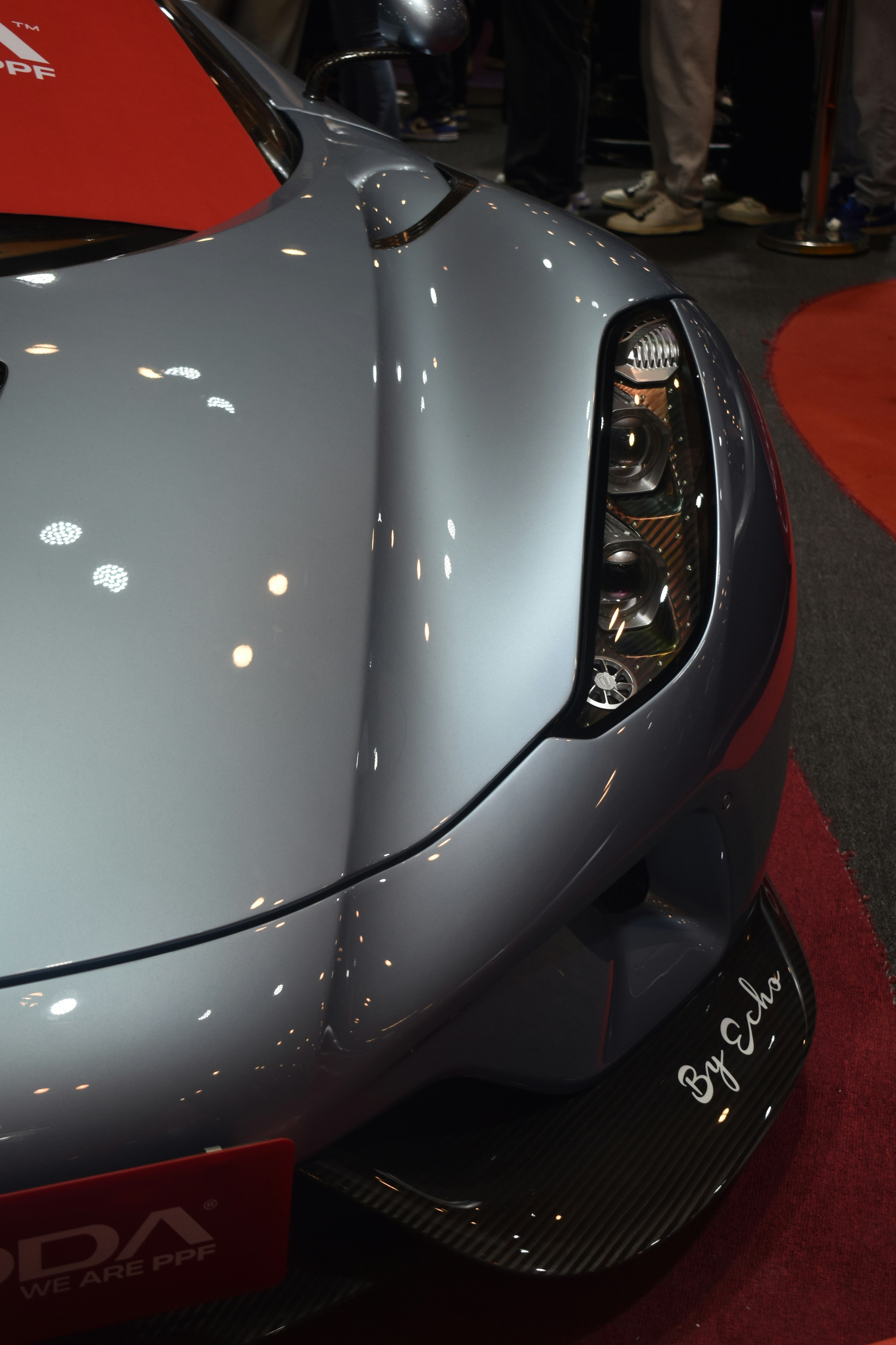 A close up of a sports car on a red carpet