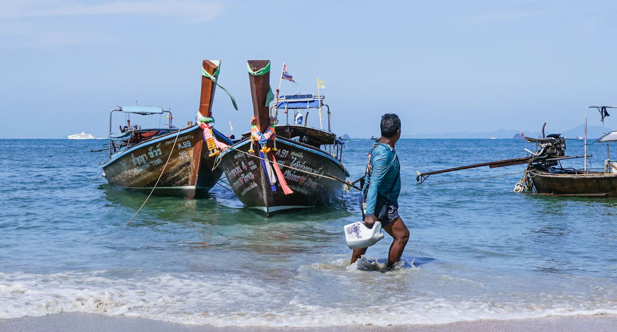 คนขับเรือหางยาวนำเรือเข้าฝั่งที่กระบี่ · A boatman bringing a longtail in, Krabi