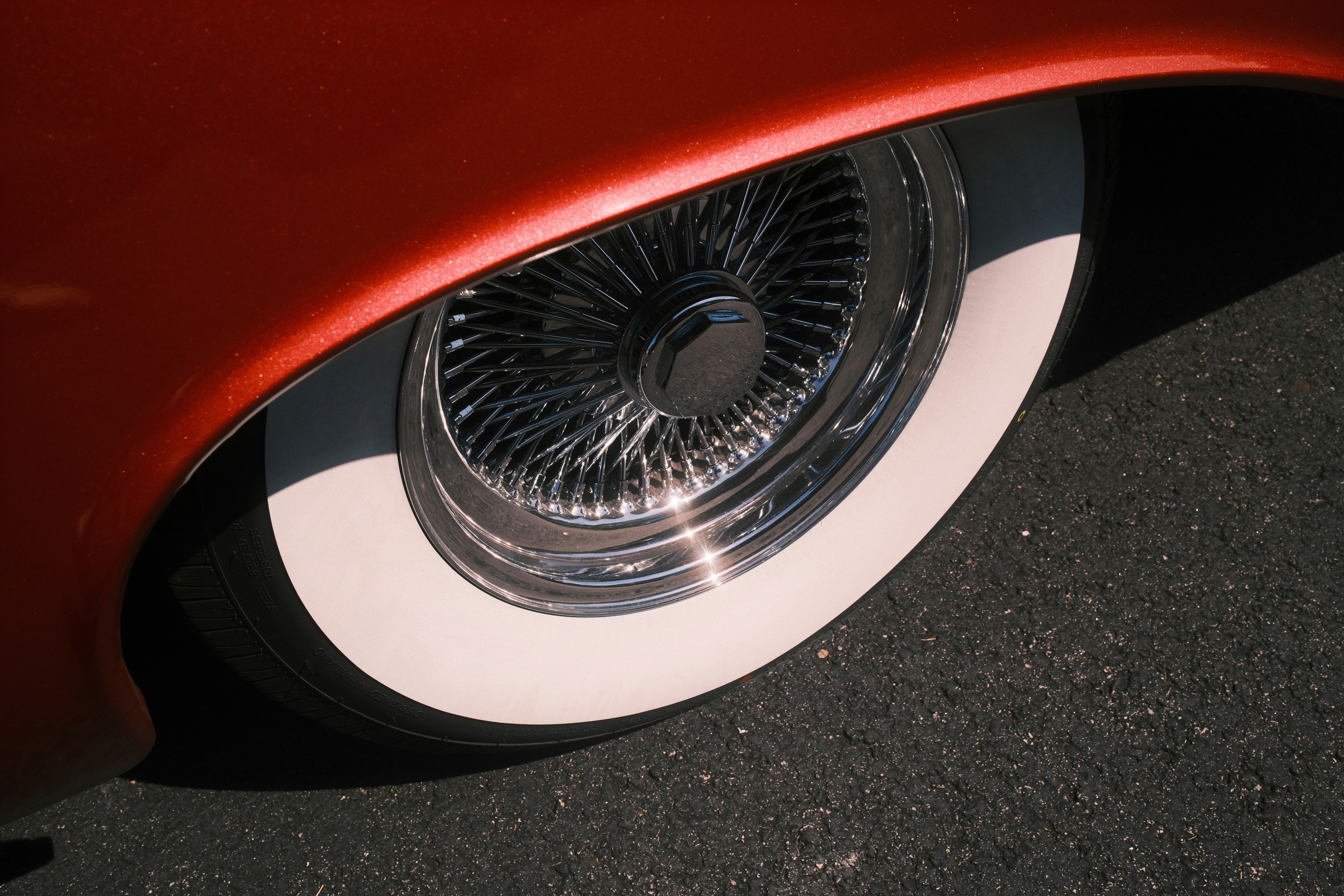A close up of a red car with chrome rims