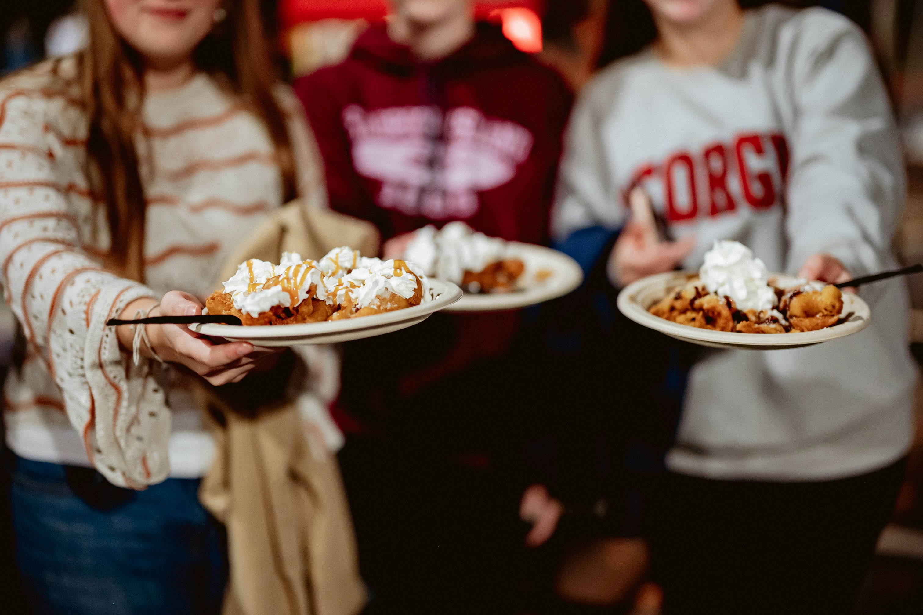 A group of people holding plates of food