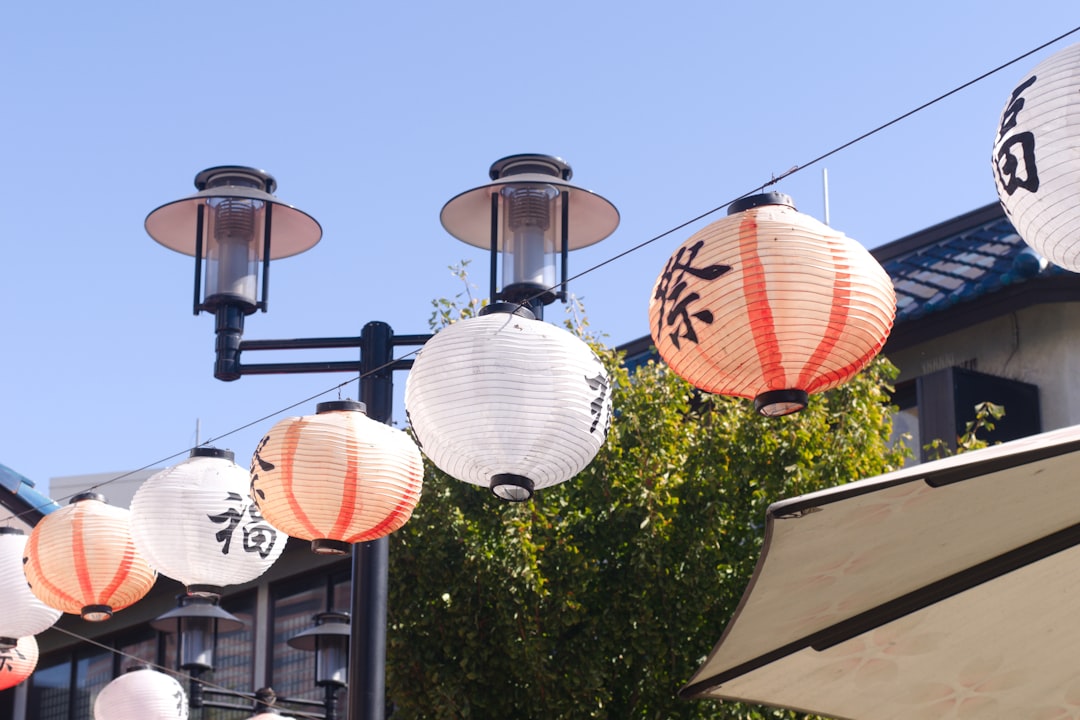 A bunch of paper lanterns hanging from the side of a building
