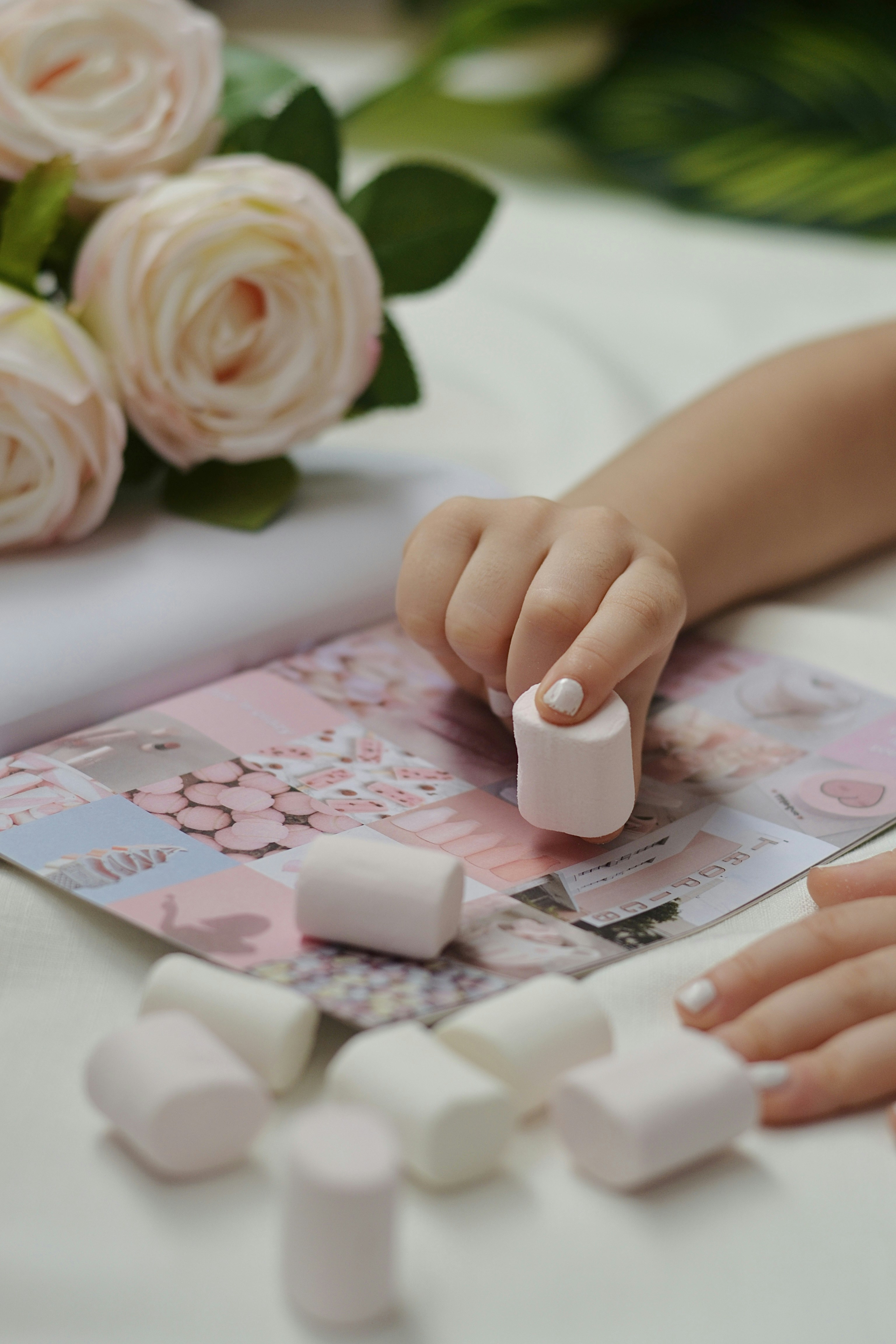 A close up of a person putting marshmallows on a table