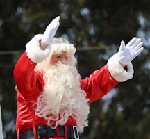 A man dressed as santa claus waves to the crowd