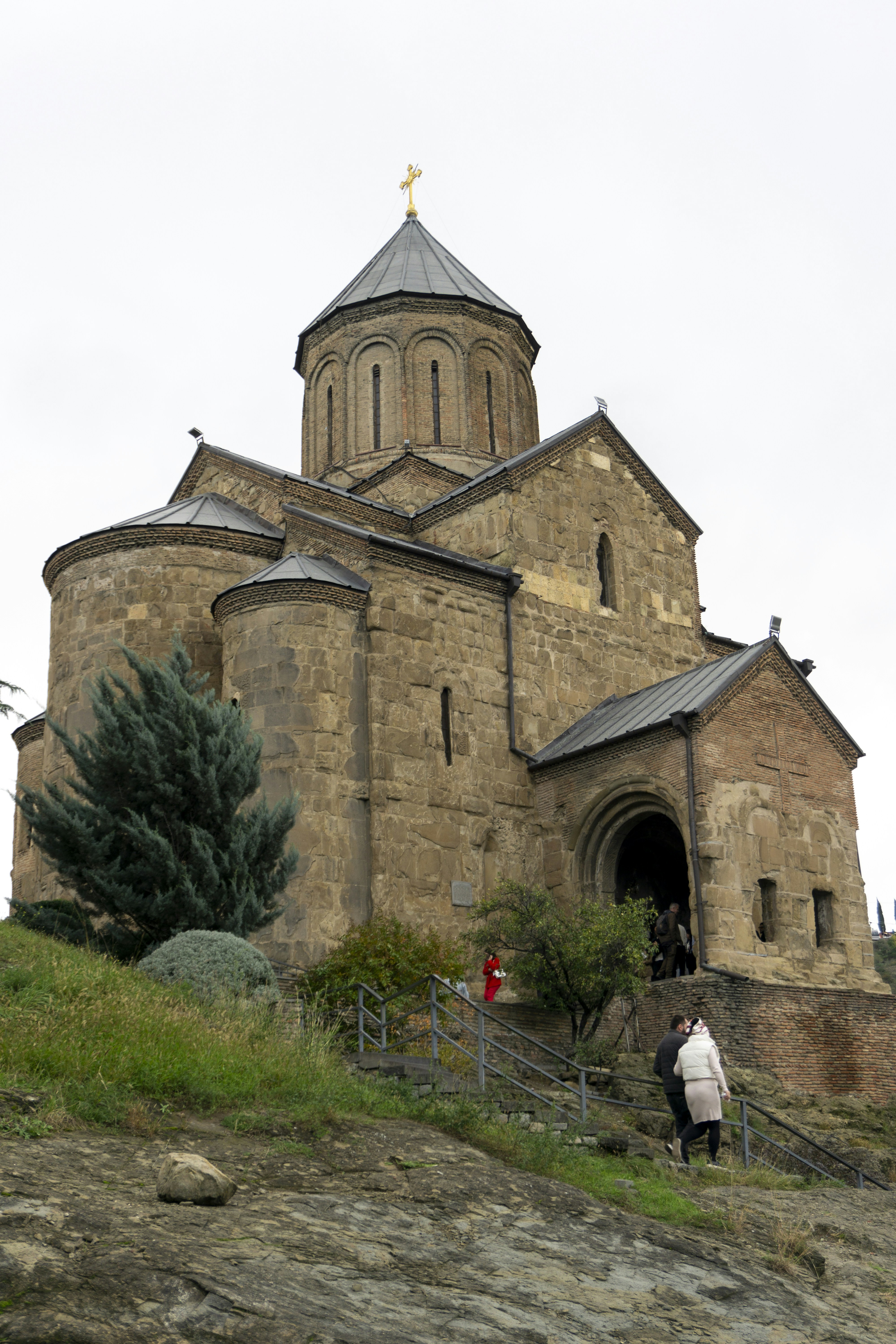 A large stone church with a steeple on top of a hill