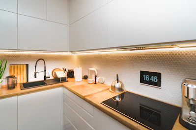 A kitchen with white cabinets and a black stove top