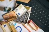 A calculator sitting on top of a pile of money