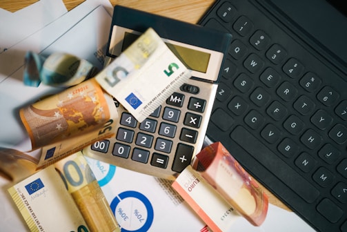 A calculator sitting on top of a pile of money