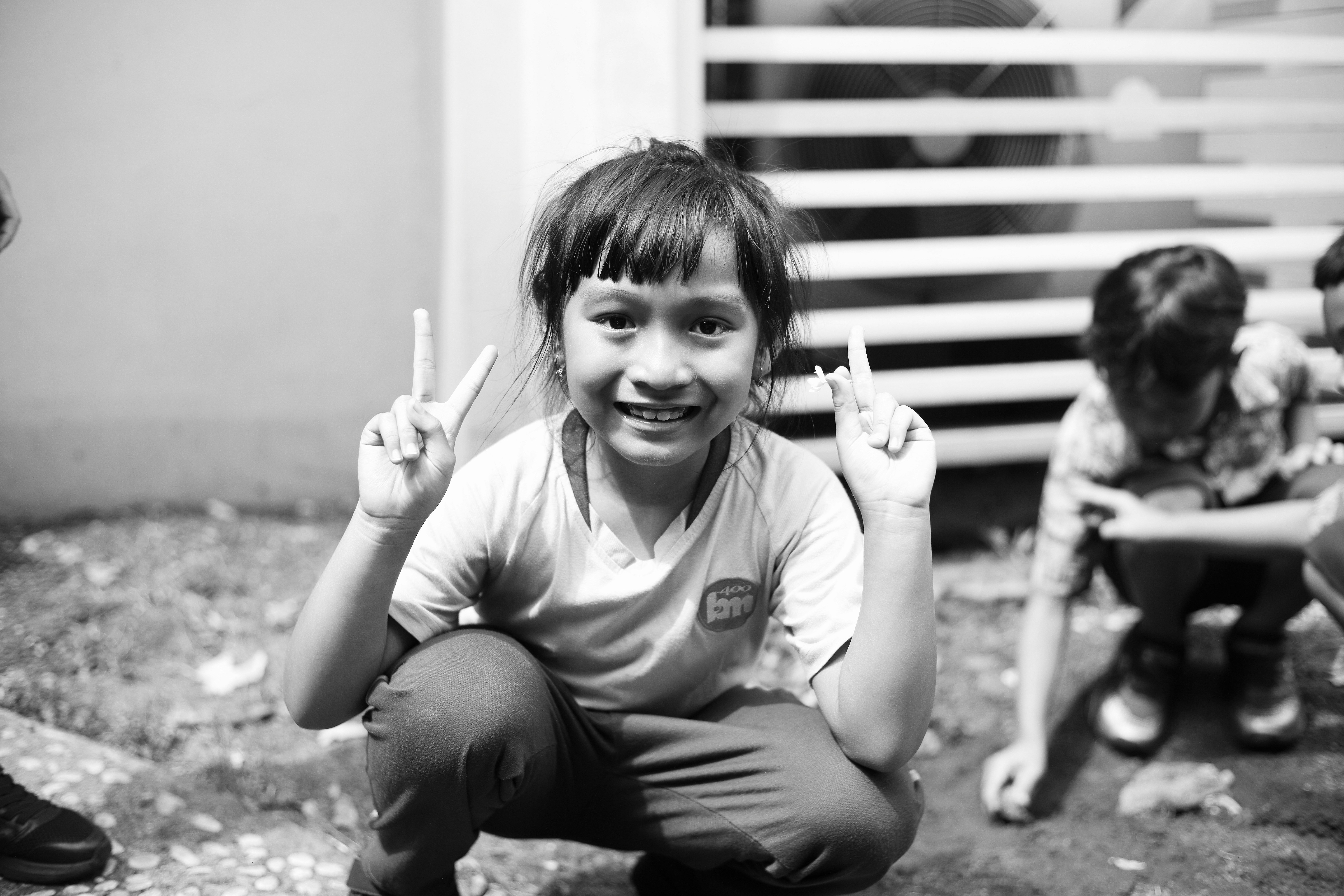 A little girl sitting on the ground with a toothbrush in her hand