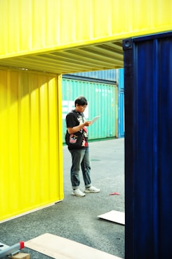A man standing in front of a yellow and blue building