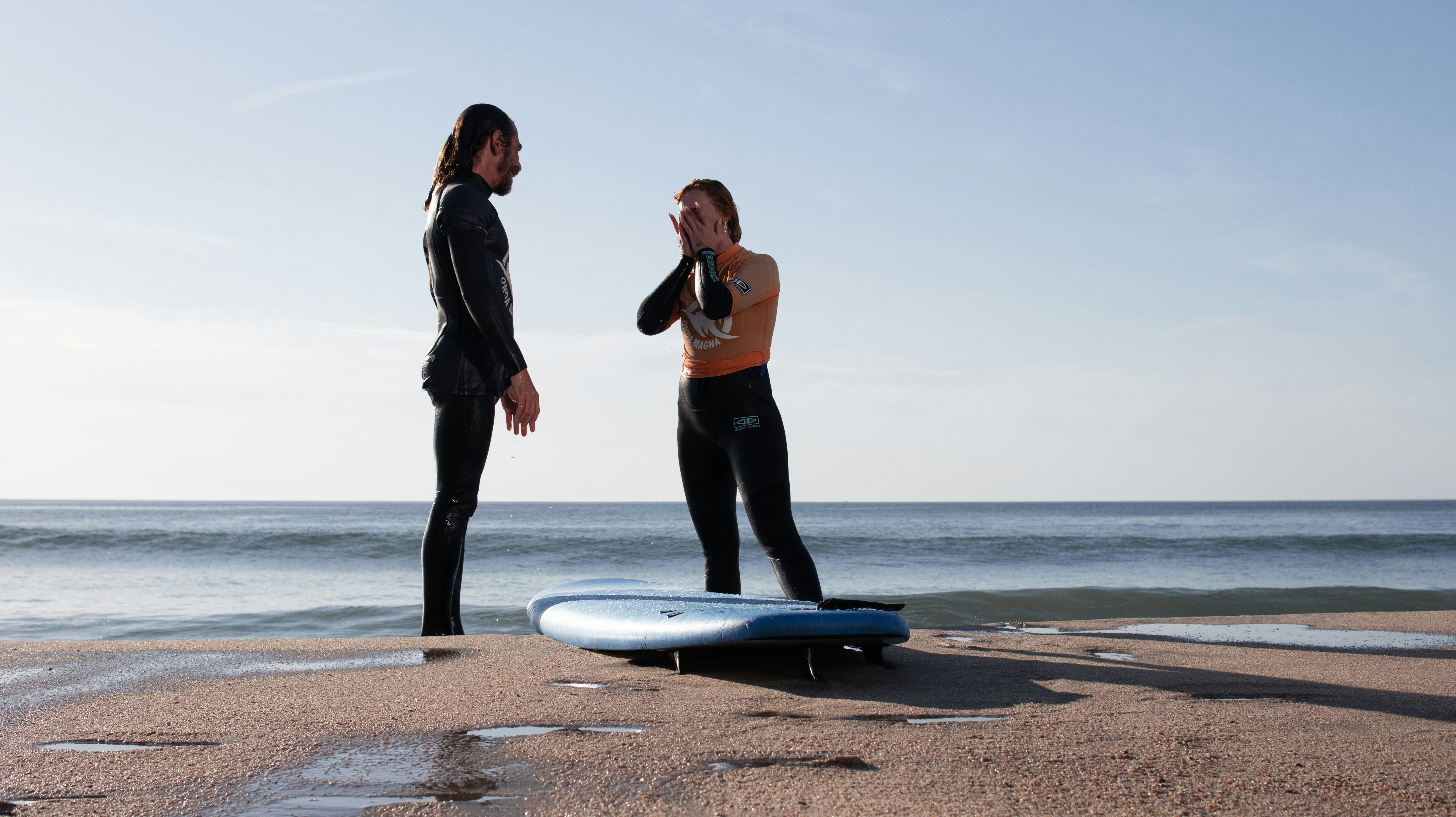 A couple of people that are standing on a surfboard
