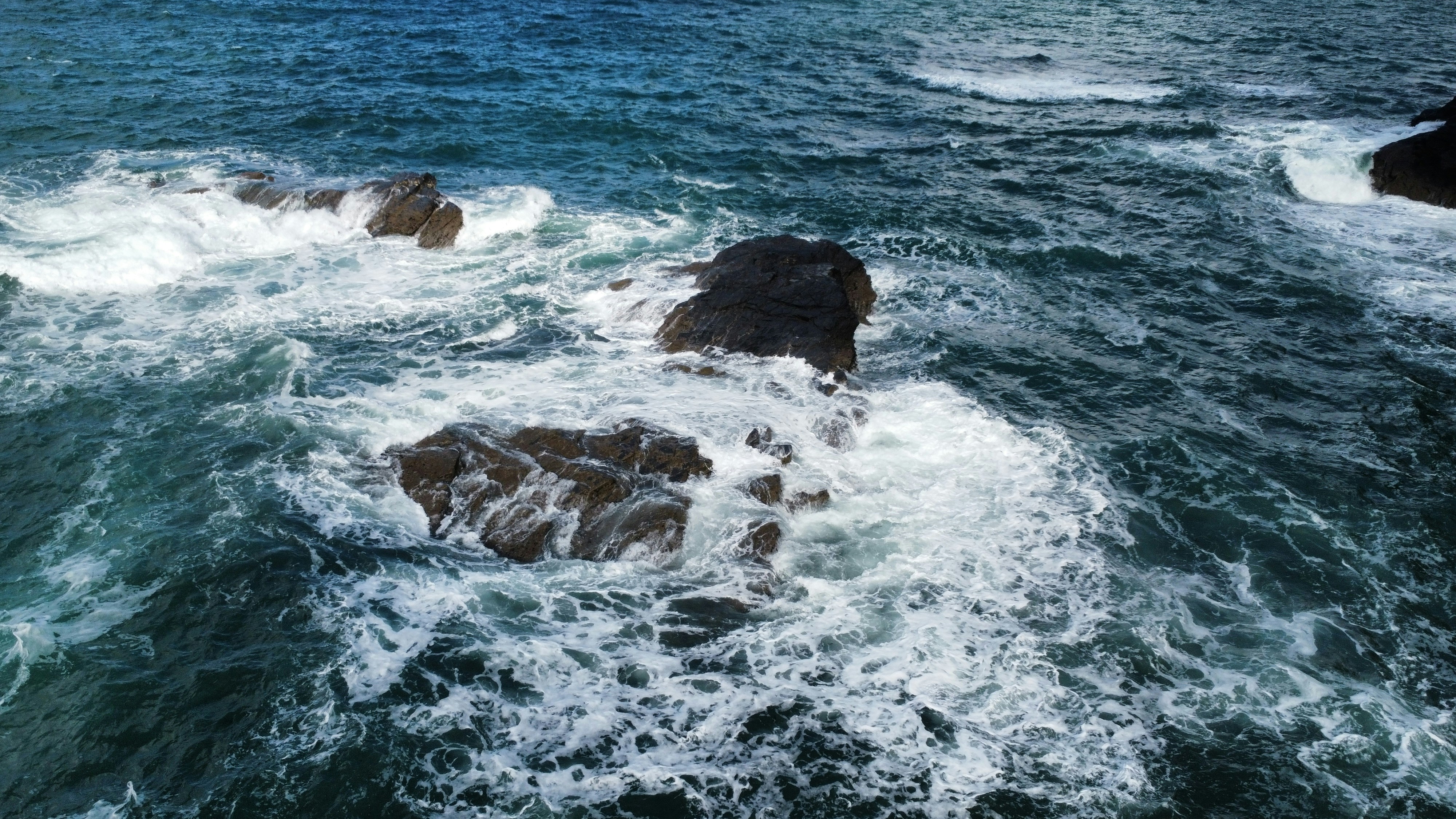 A group of rocks sitting in the middle of a body of water