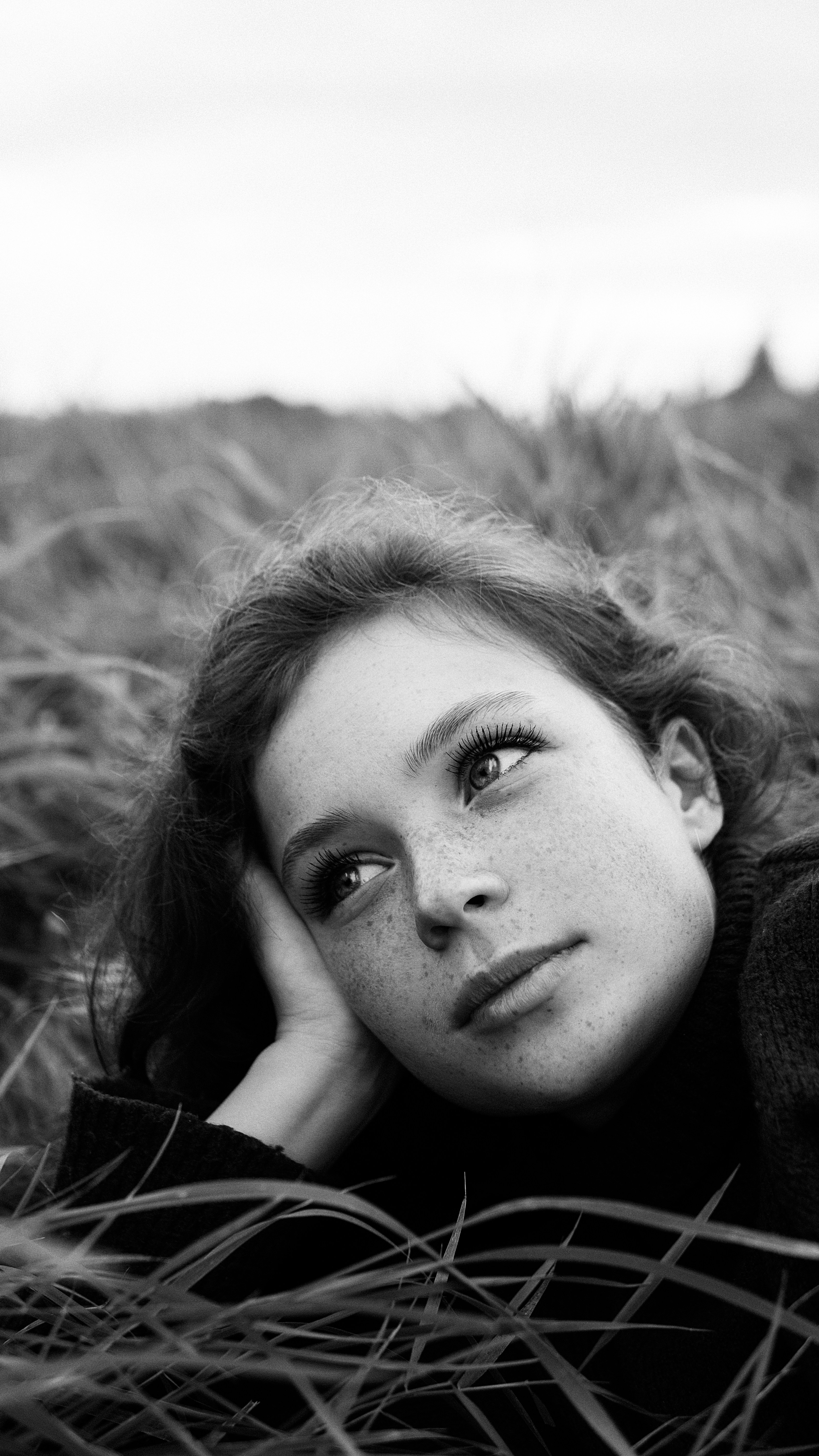 A woman laying in a field of tall grass