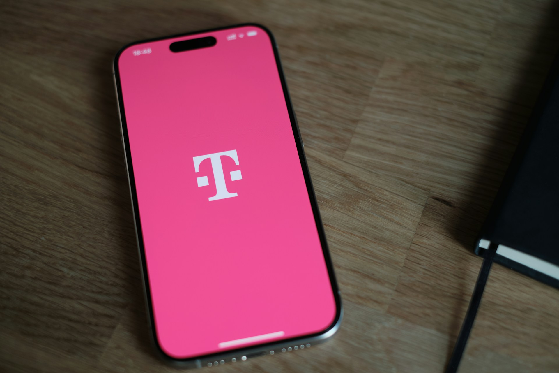 A pink phone sitting on top of a wooden table