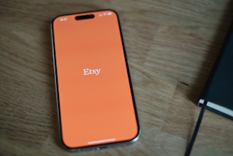 An orange cell phone sitting on top of a wooden table