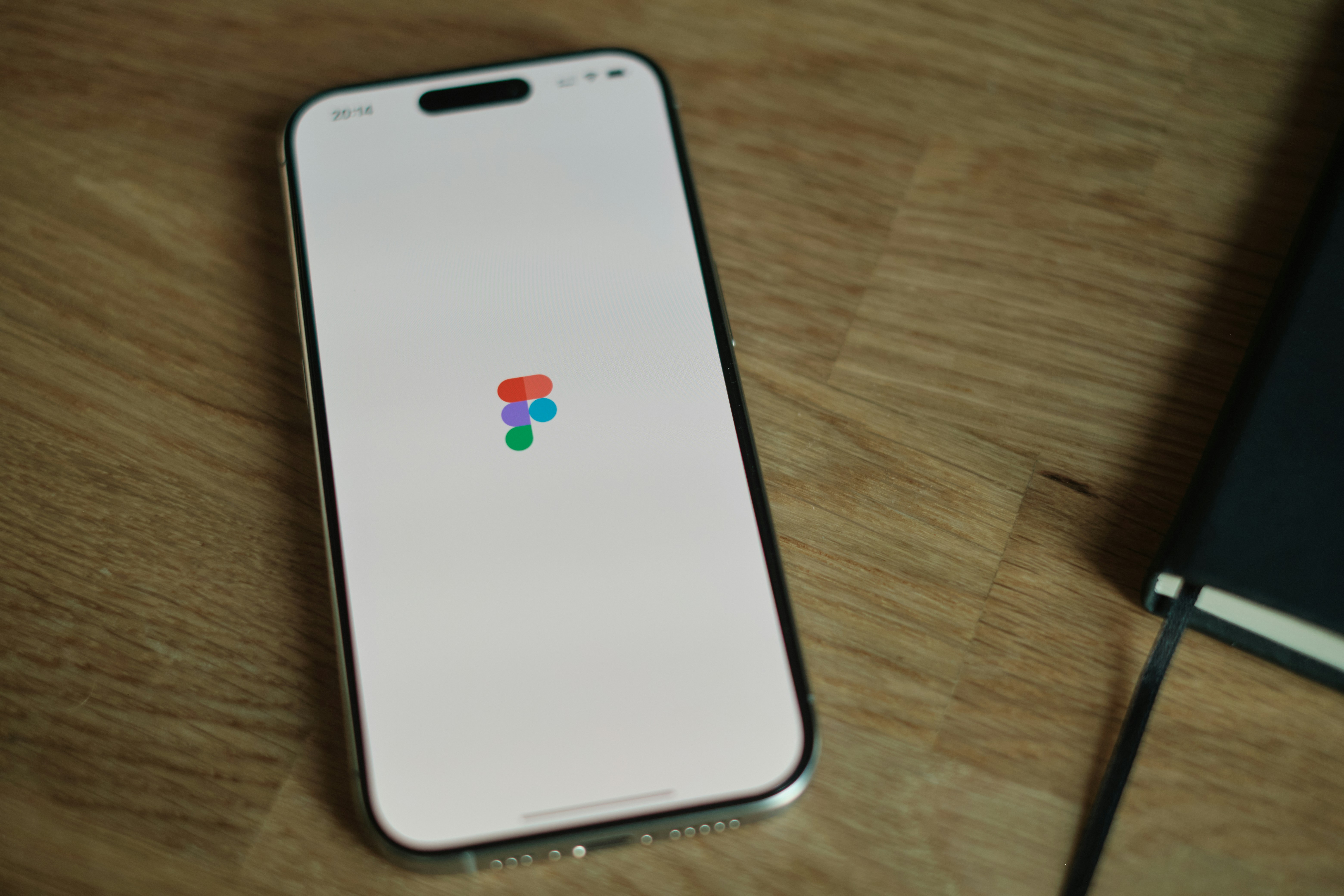 木製のテーブルの上に置かれた携帯電話