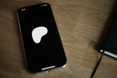 A cell phone sitting on top of a wooden table