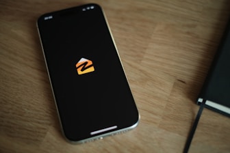 A cell phone sitting on top of a wooden table