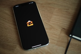 A cell phone sitting on top of a wooden table