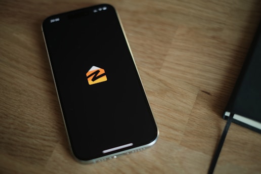 A cell phone sitting on top of a wooden table