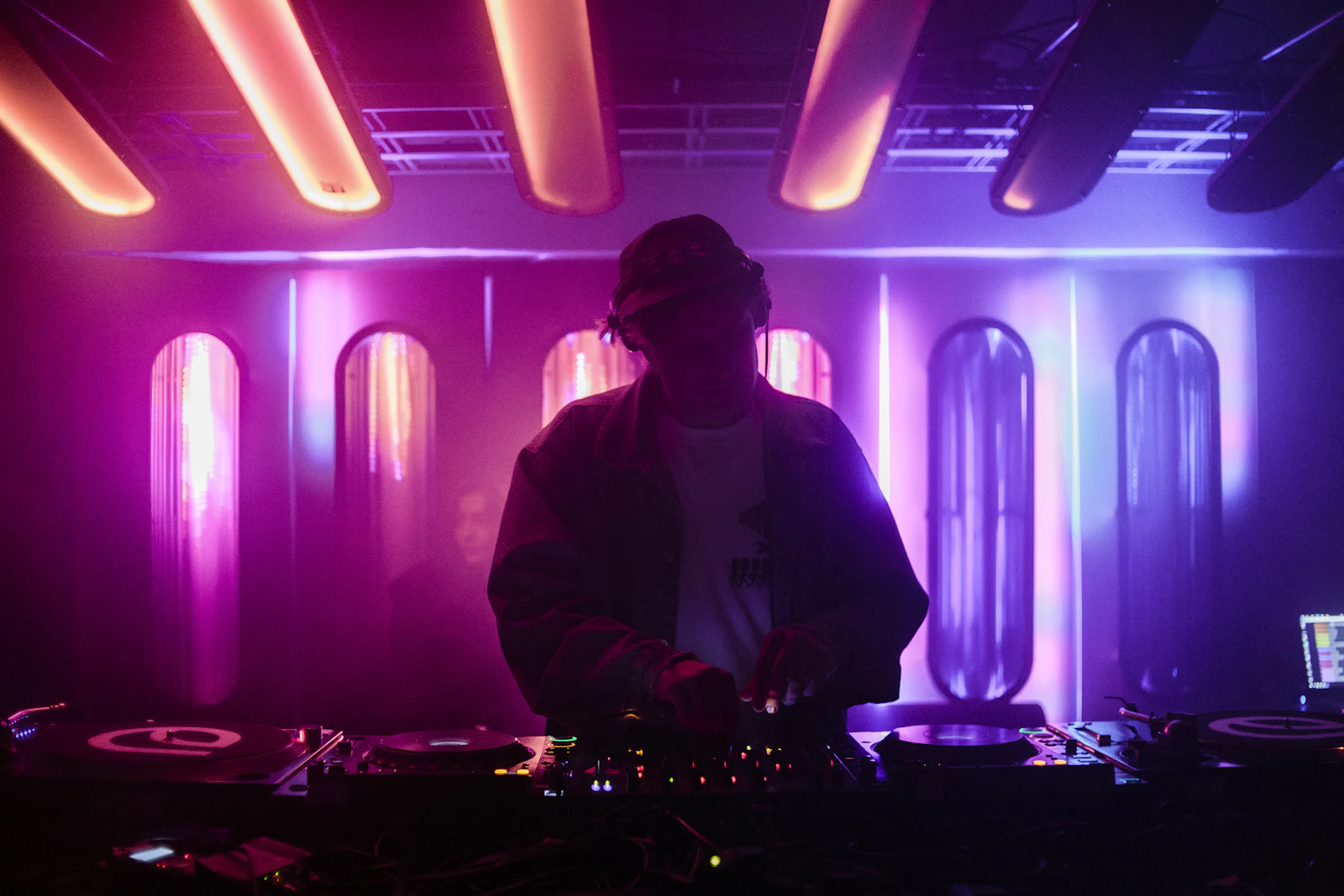 DJ silhouetted against purple and pink stage lights